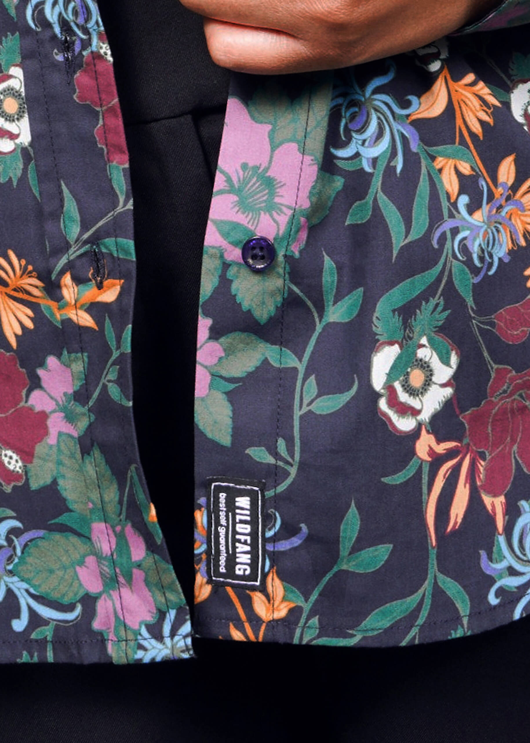 1X=Floral-patterned shirt with a brand label on a dark background