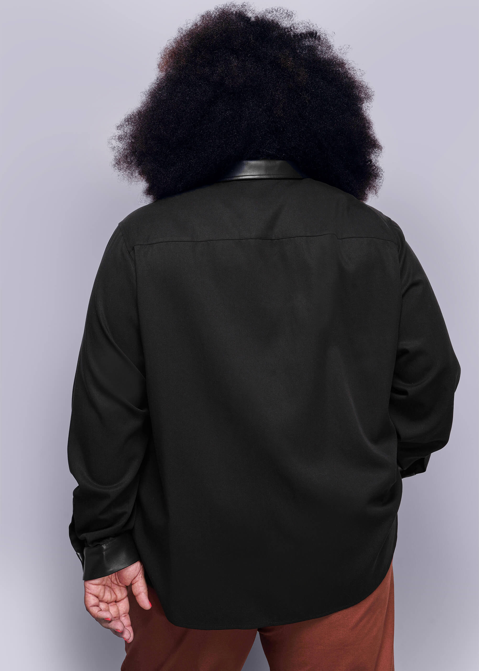 1X=Back view of person wearing a black button up shirt with vegan leather collar on a plain background