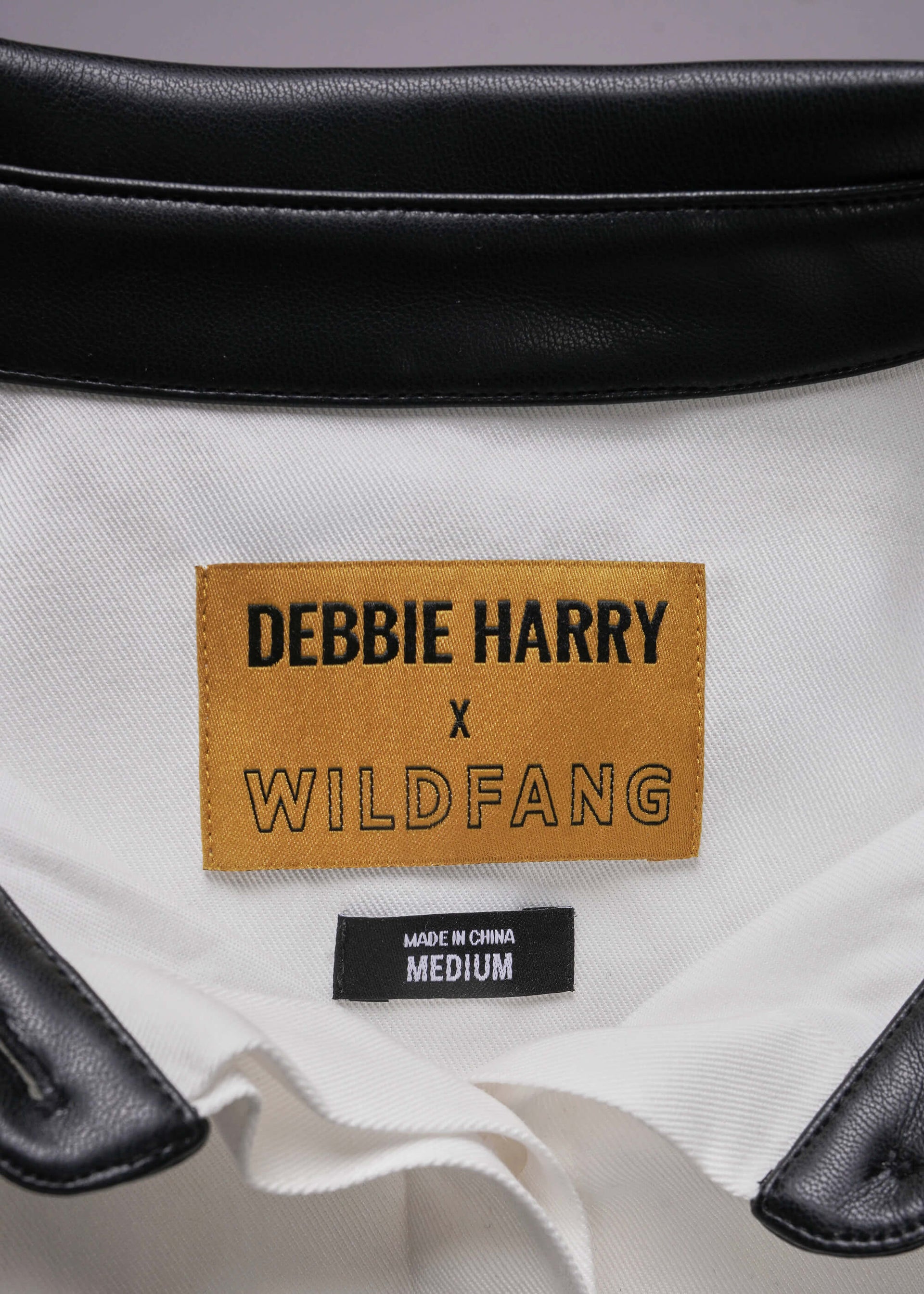Close-up of a product with a 'Debbie Harry x Wildfang' label on a white background.