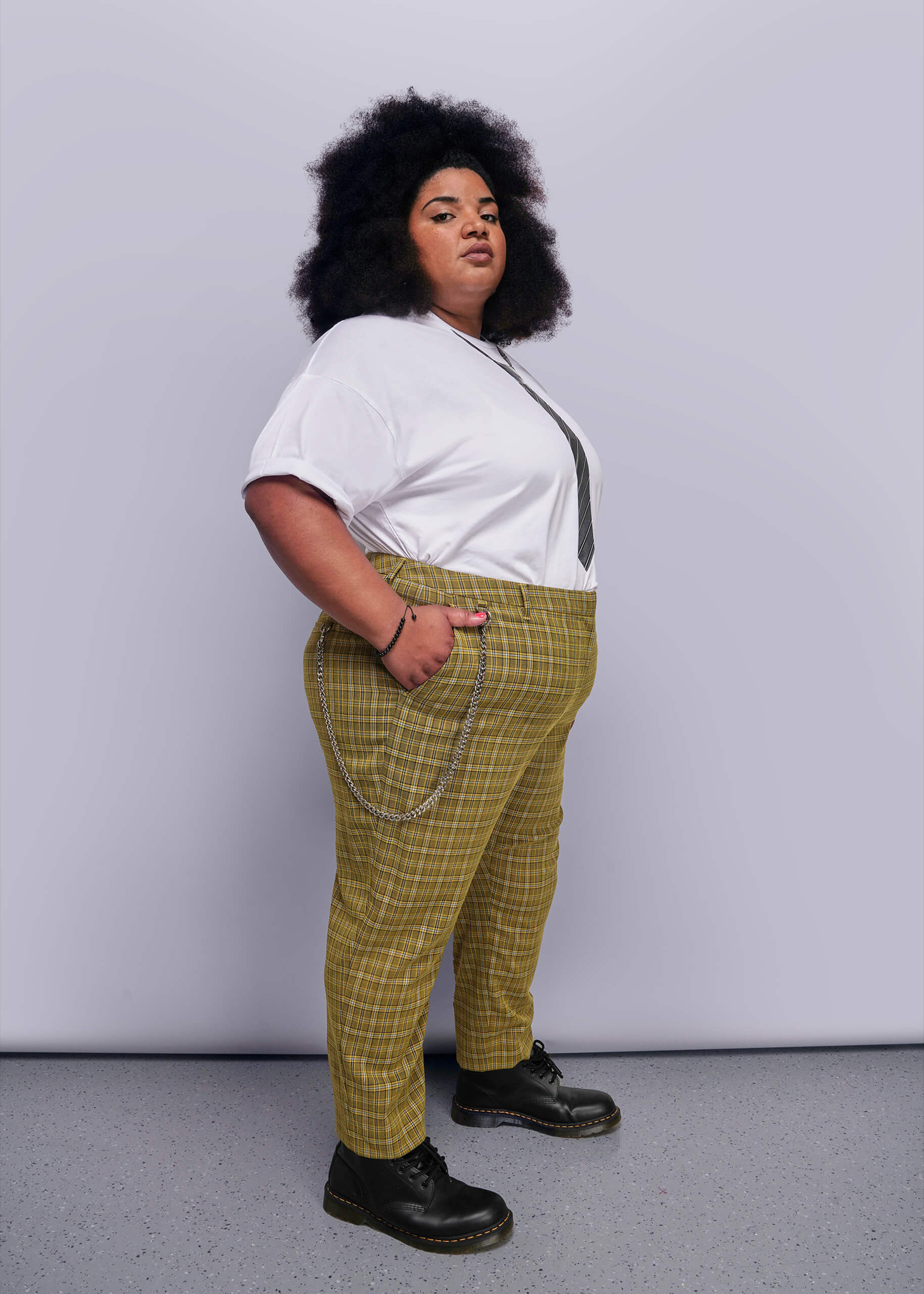 1X=Person wearing a white tee and yellow plaid pants against a plain background