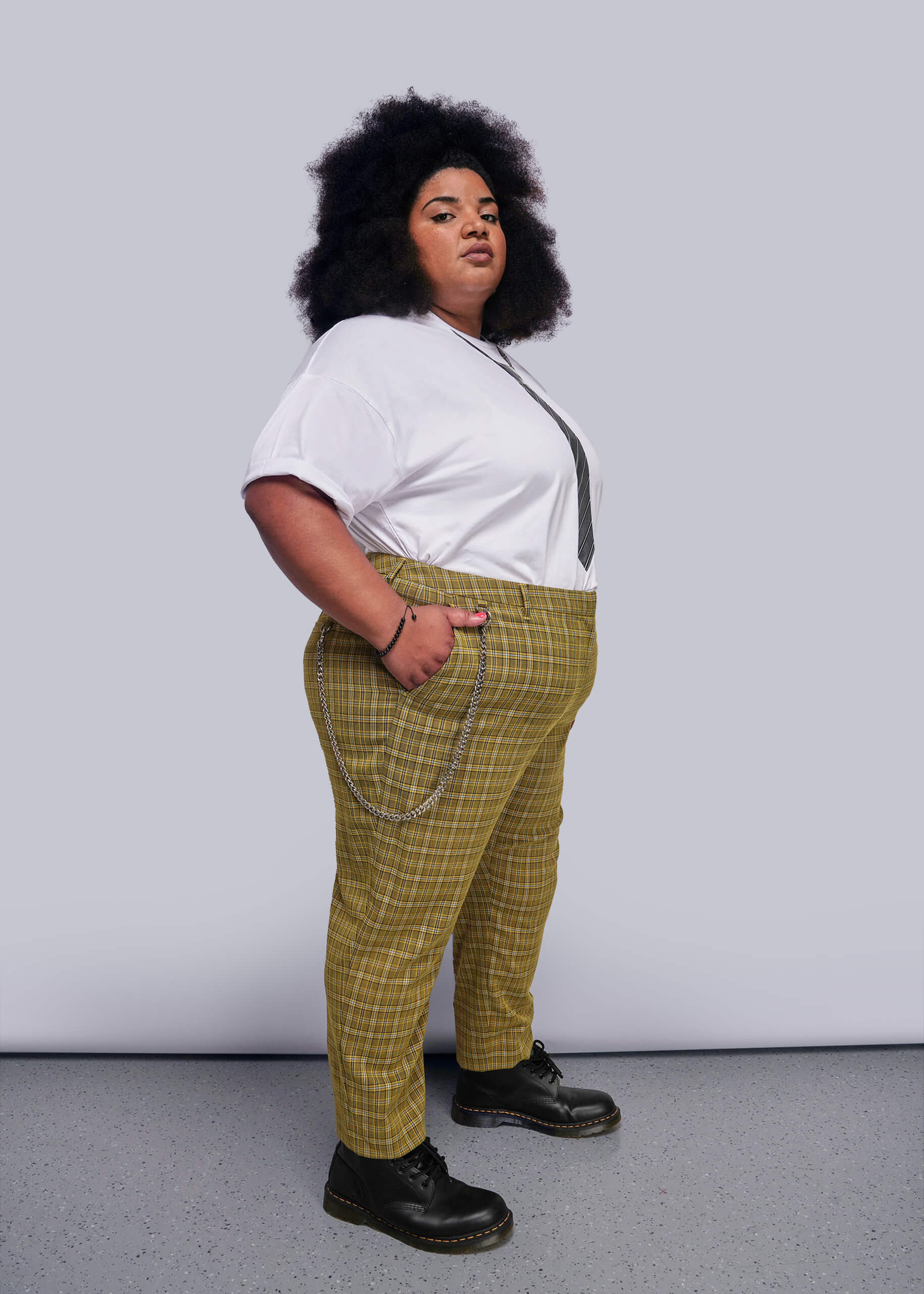 1X=Person wearing a white tee and yellow plaid pants against a plain background