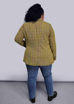 1X=Back view of person wearing a yellow plaid jacket and blue jeans against a white background