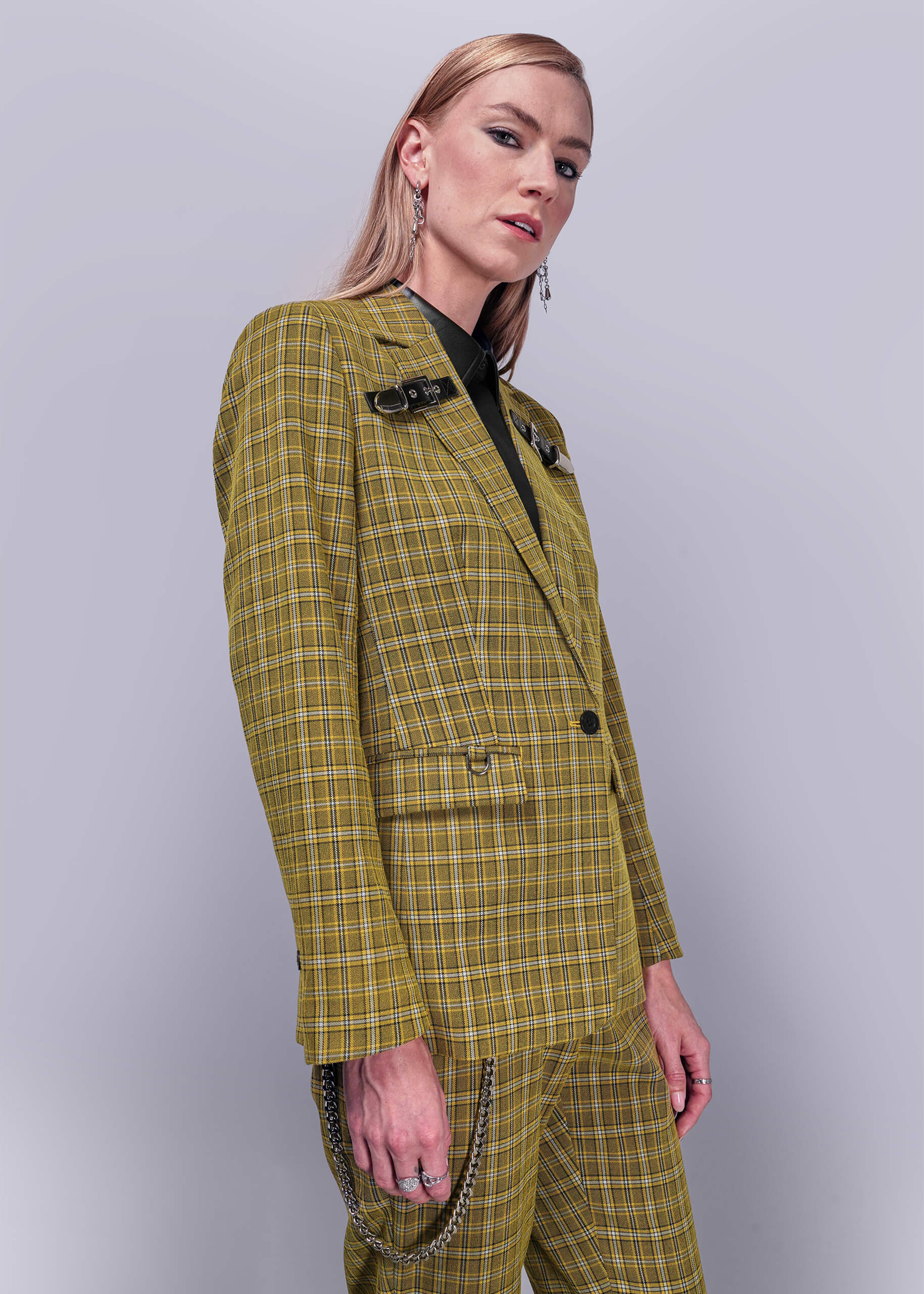 S=Side view of person wearing a yellow plaid suit against a plain background