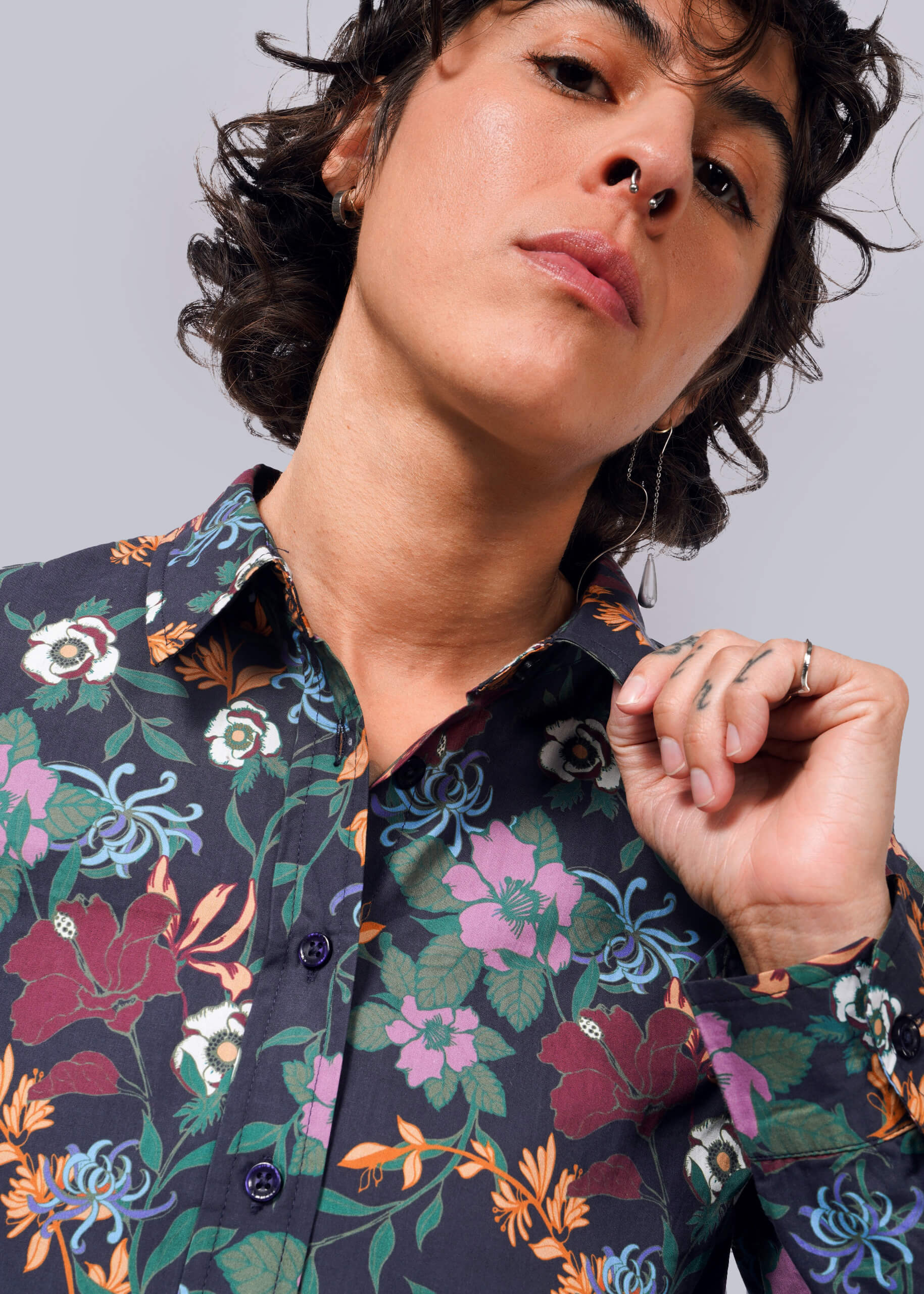 S=Person wearing a floral patterned shirt against a neutral background