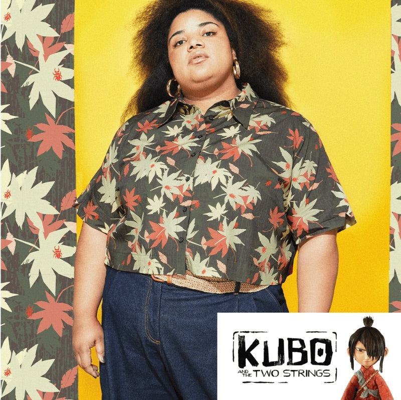 Person wearing a leaf printed button up shirt with a yellow background and 'Kubo and the Two Strings' logo.