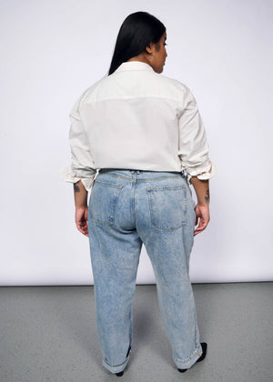 1X=Back view of person with long black hair wearing The Peanuts x Wildfang Long Sleeve Button Up shirt and jeans.