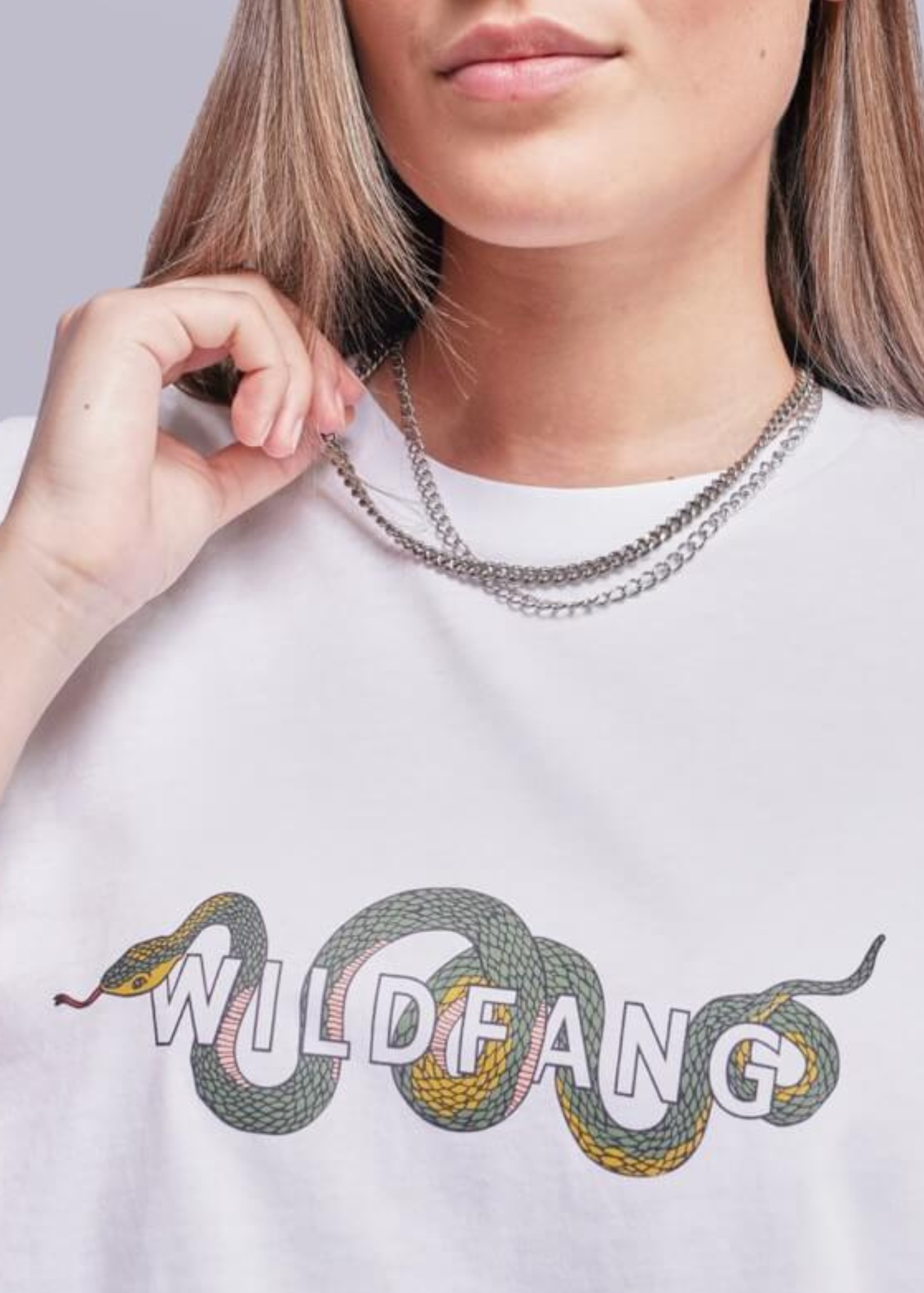 S=Close up of model wearing white tee with Wildfang logo and snake design on it.