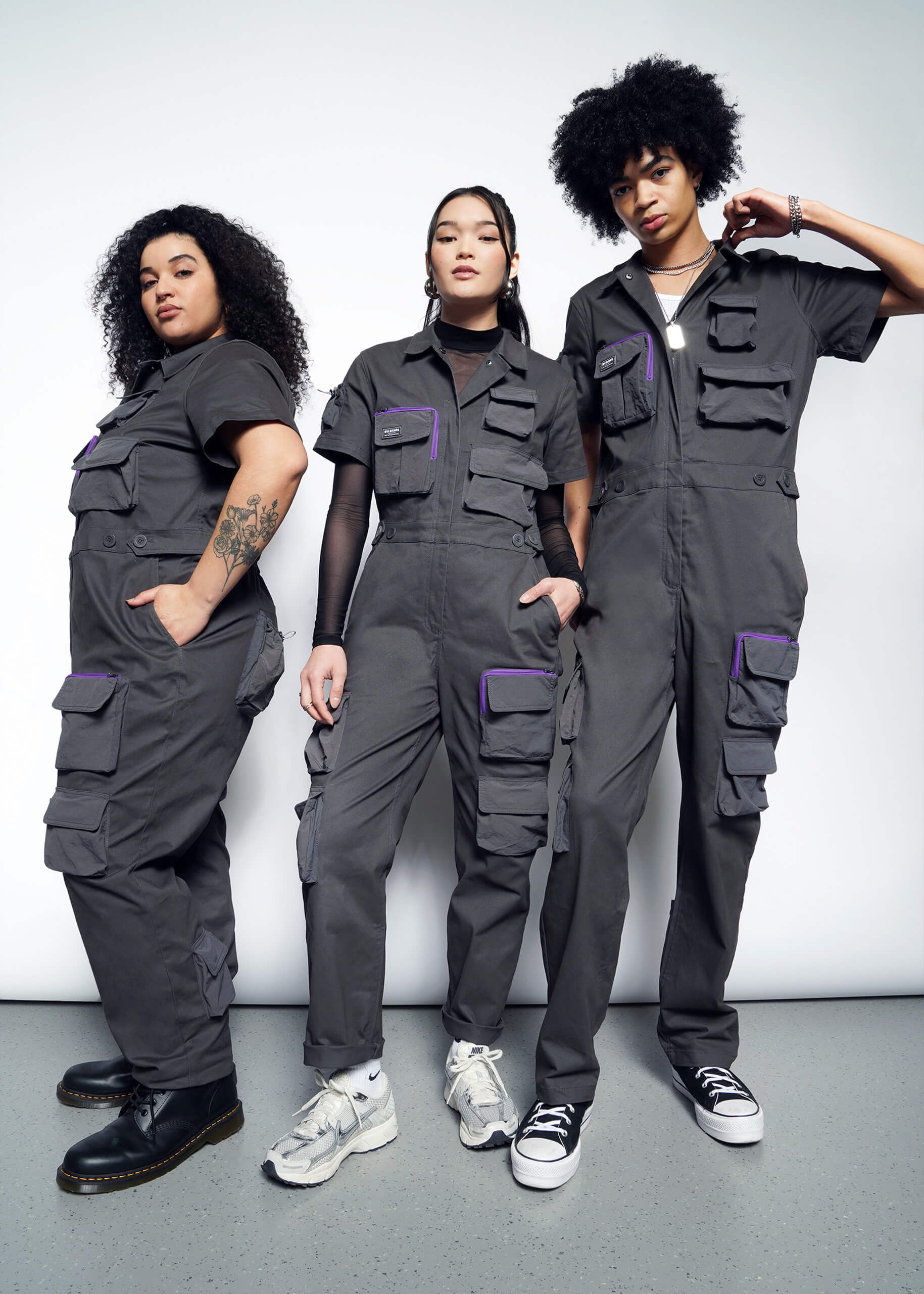 Group of models in matching grey limited edition coveralls from TACO BELL® x Wildfang