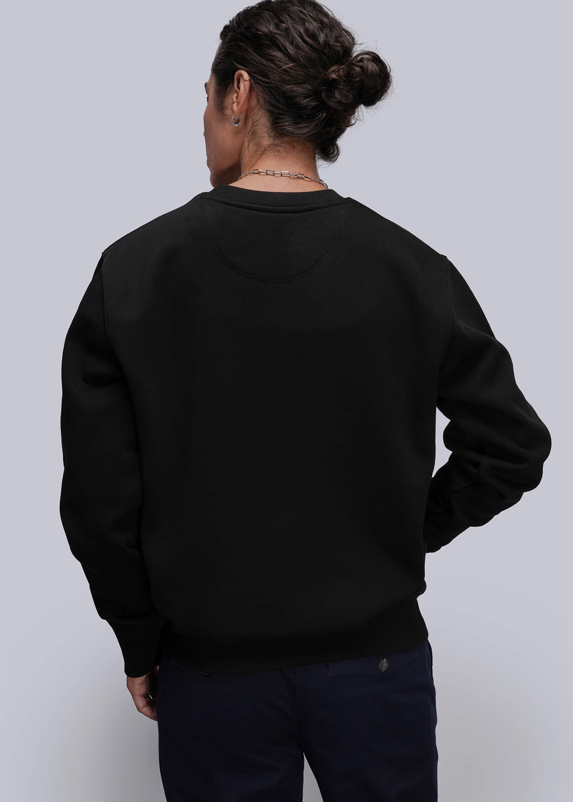 S=Person wearing a black sweatshirt against a plain background