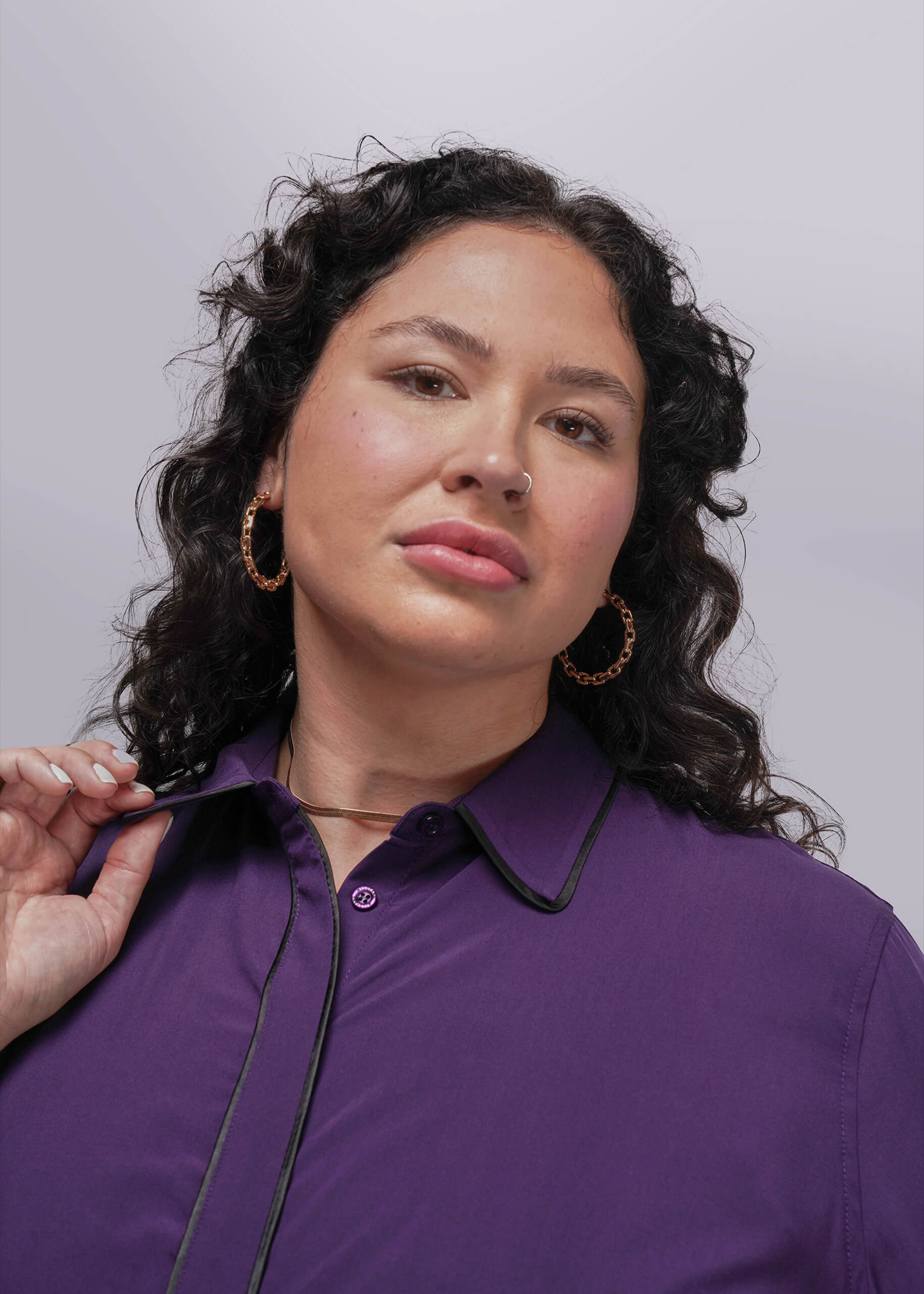 1X=Woman wearing a purple shirt with a plain background