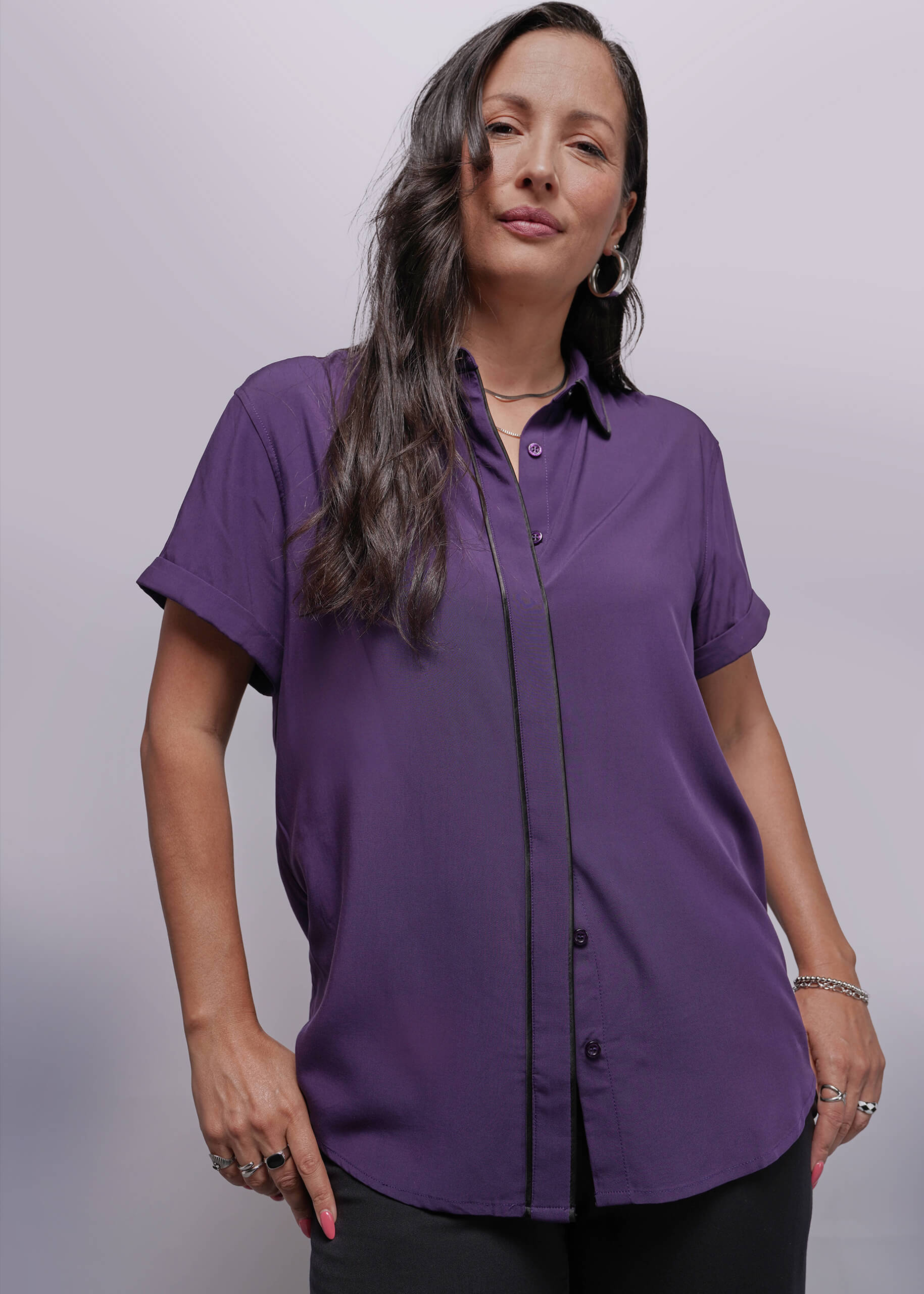 S=Woman wearing a purple shirt against a plain background