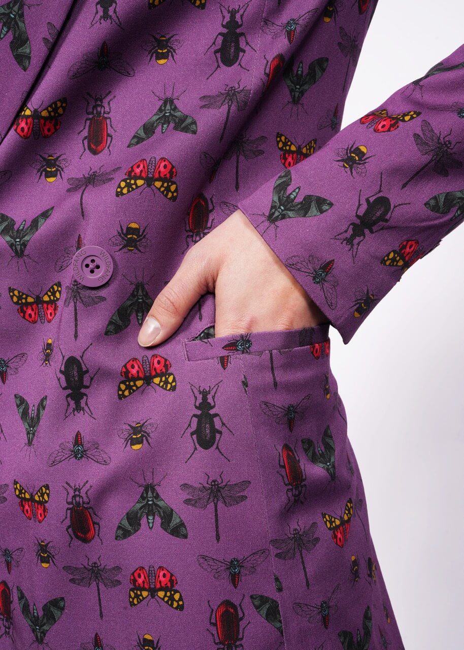 S= Close up of hand in purple bug printed blazer side picket.