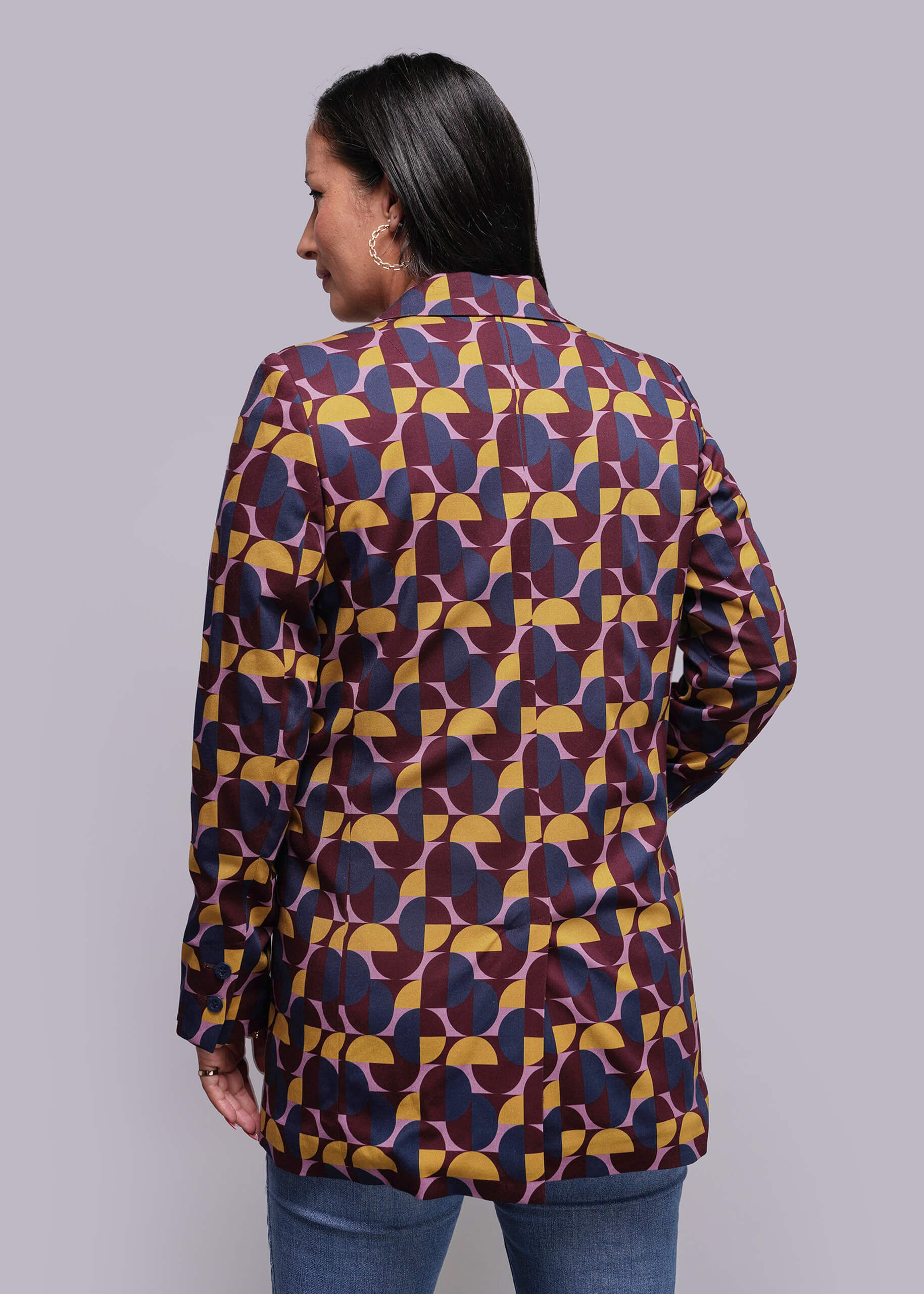 S=Woman wearing a patterned shirt with a plain background