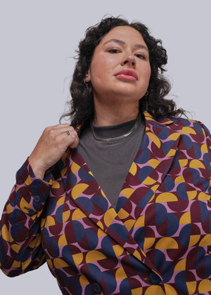 1X-Person wearing a colorful geometric-patterned jacket against a plain background