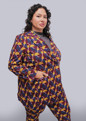 1X=Person wearing a colorful patterned suit against a plain background