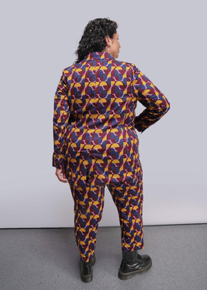1X=Person wearing a colorful geometric patterned outfit against a plain background