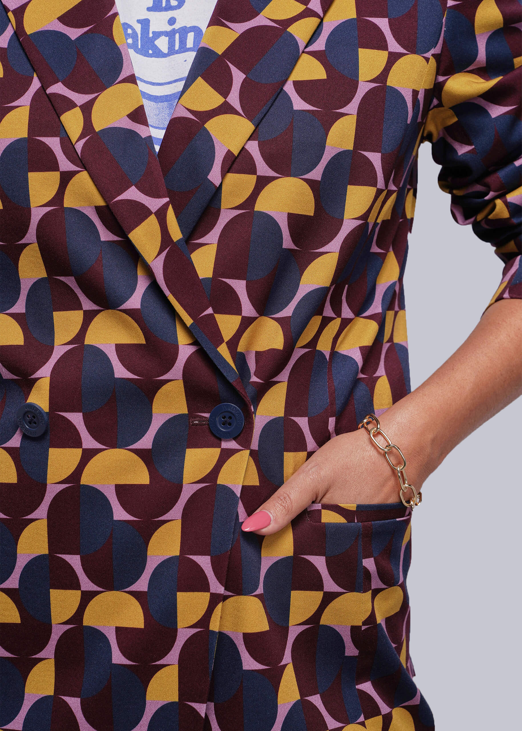 S=Patterned outfit with geometric design in purple, yellow, and blue on a plain background