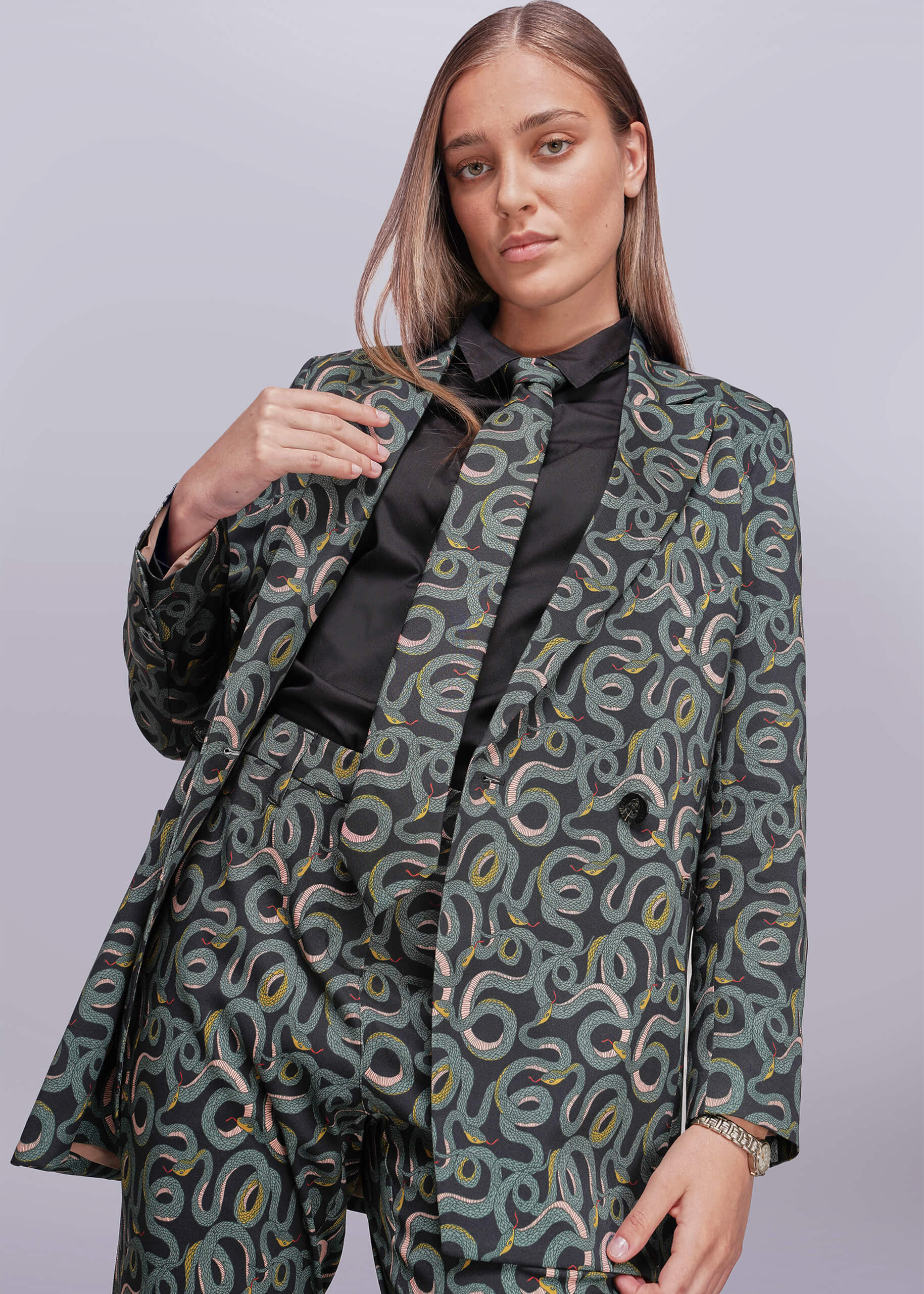S=Woman wearing a snake patterned suit with a plain background