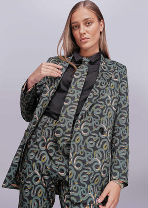 S=Woman wearing a snake patterned suit with a plain background