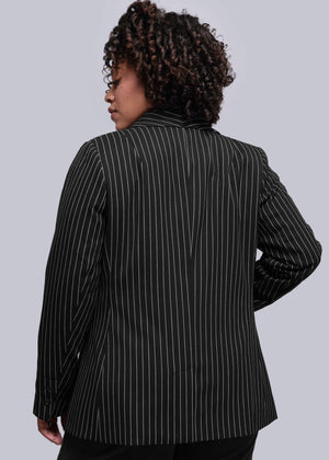 1X=Person wearing a black pinstripe blazer against a plain background