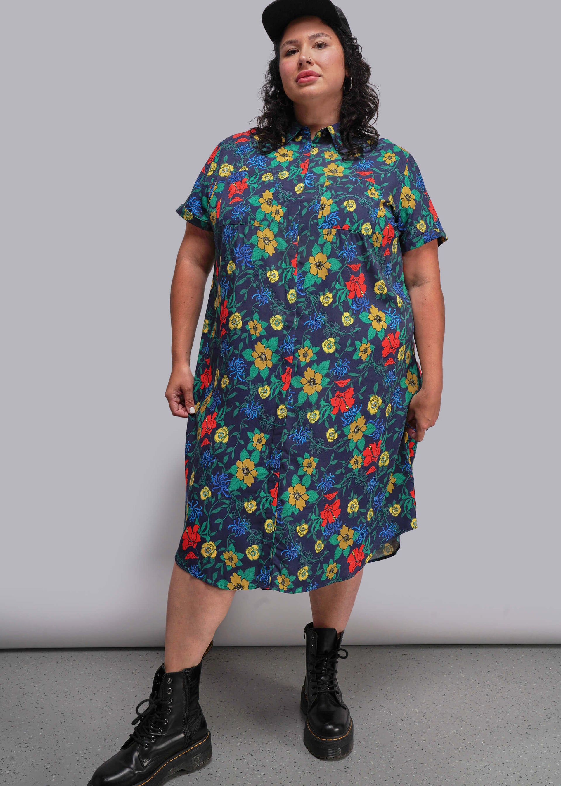 1X=Person wearing a colorful floral dress with a plain background