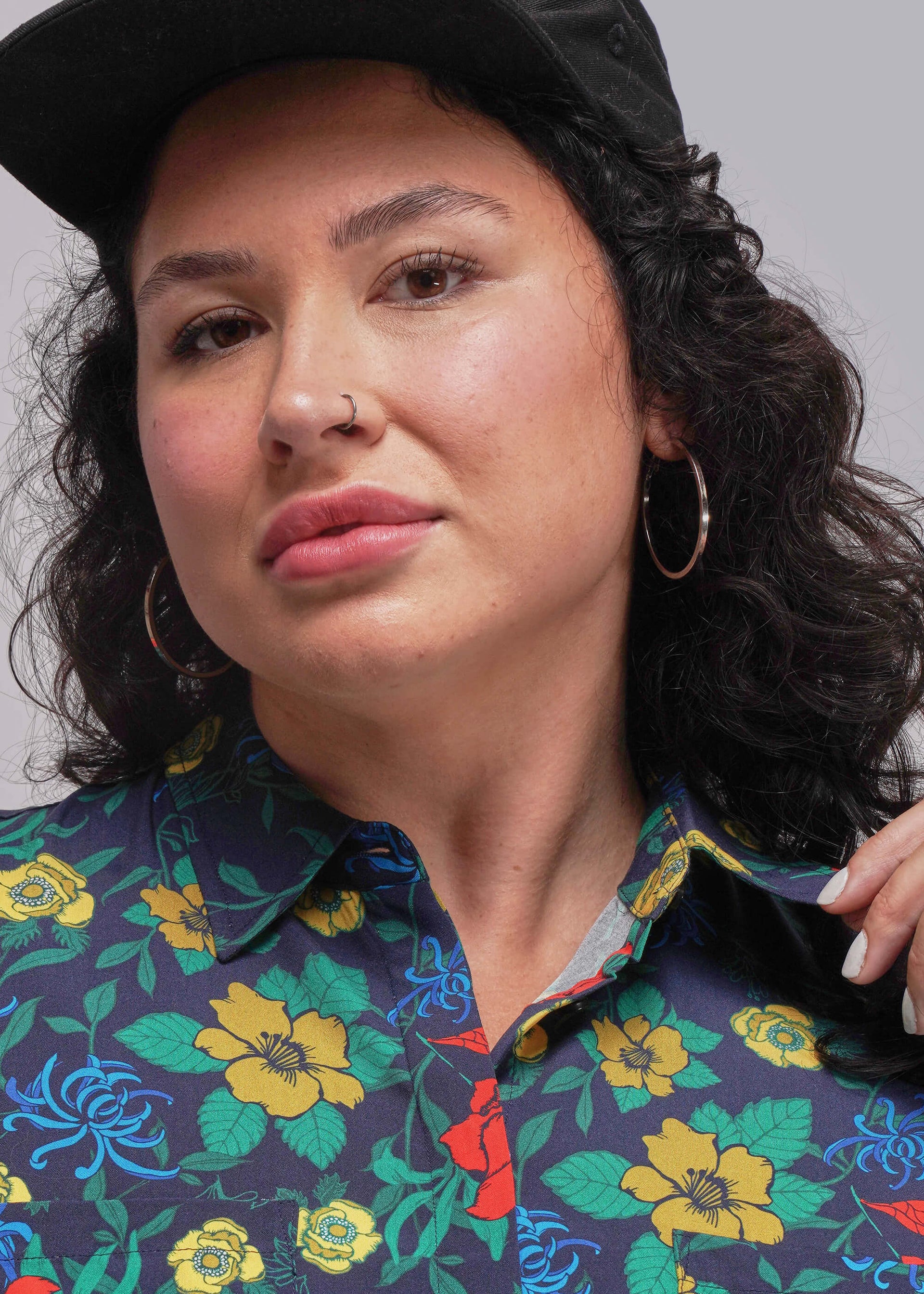 1X=Close up of person wearing a colorful floral dress to show collar with a plain background