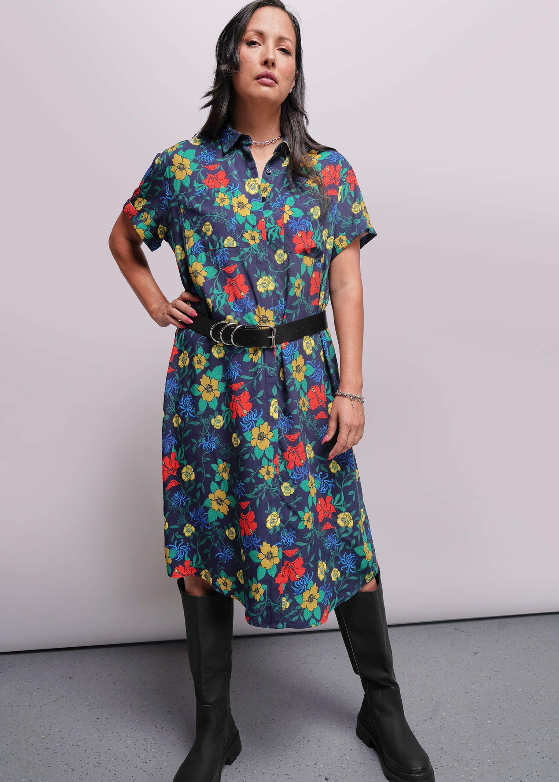 S=Woman wearing a colorful floral dress with a plain background