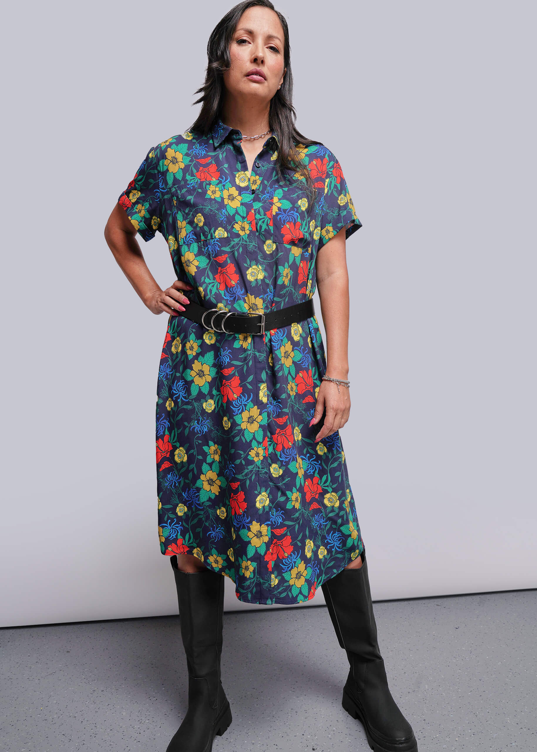 S=Woman wearing a colorful floral dress with a plain background