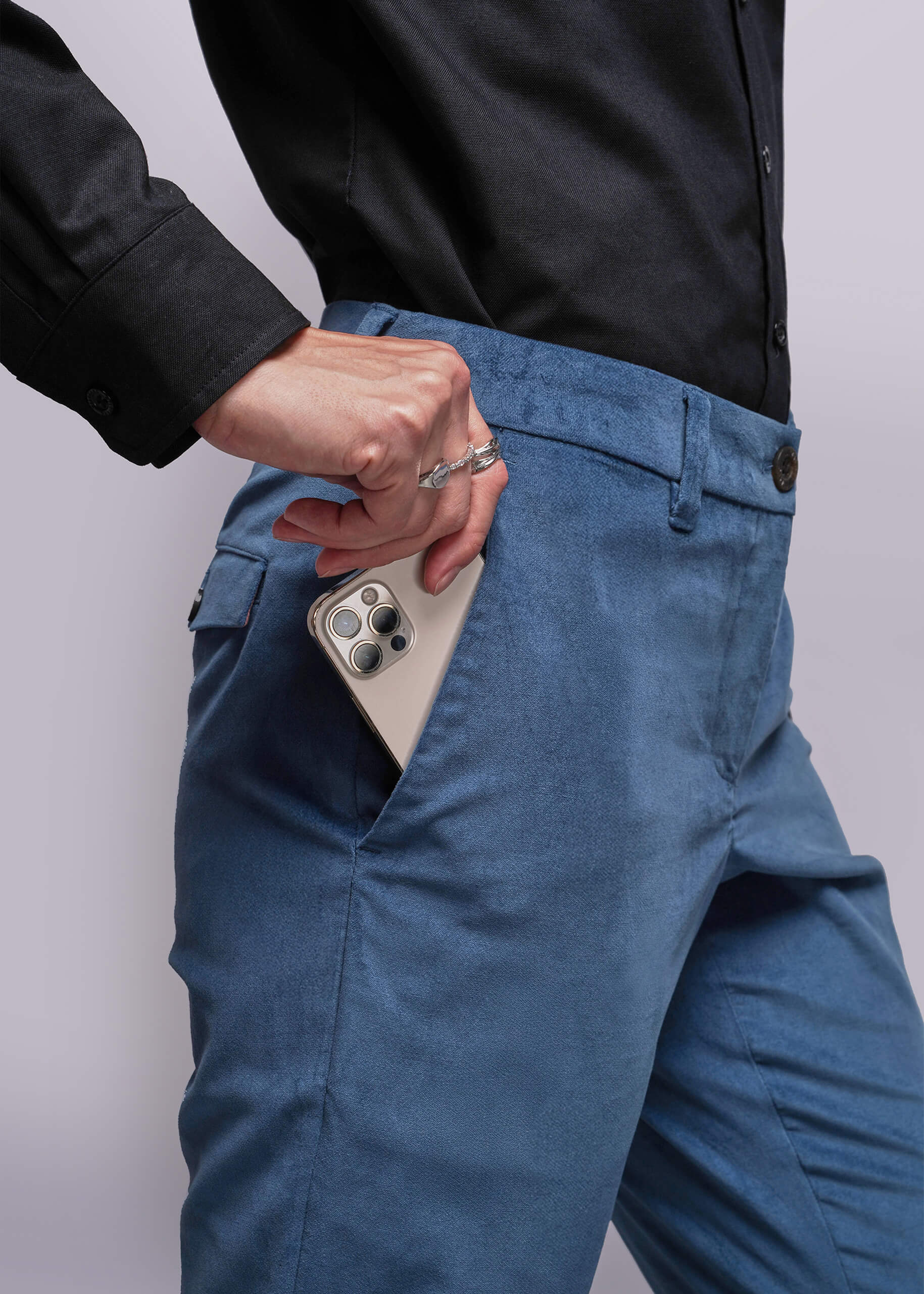 S=Person wearing blue pants with a phone in the pocket against a white background