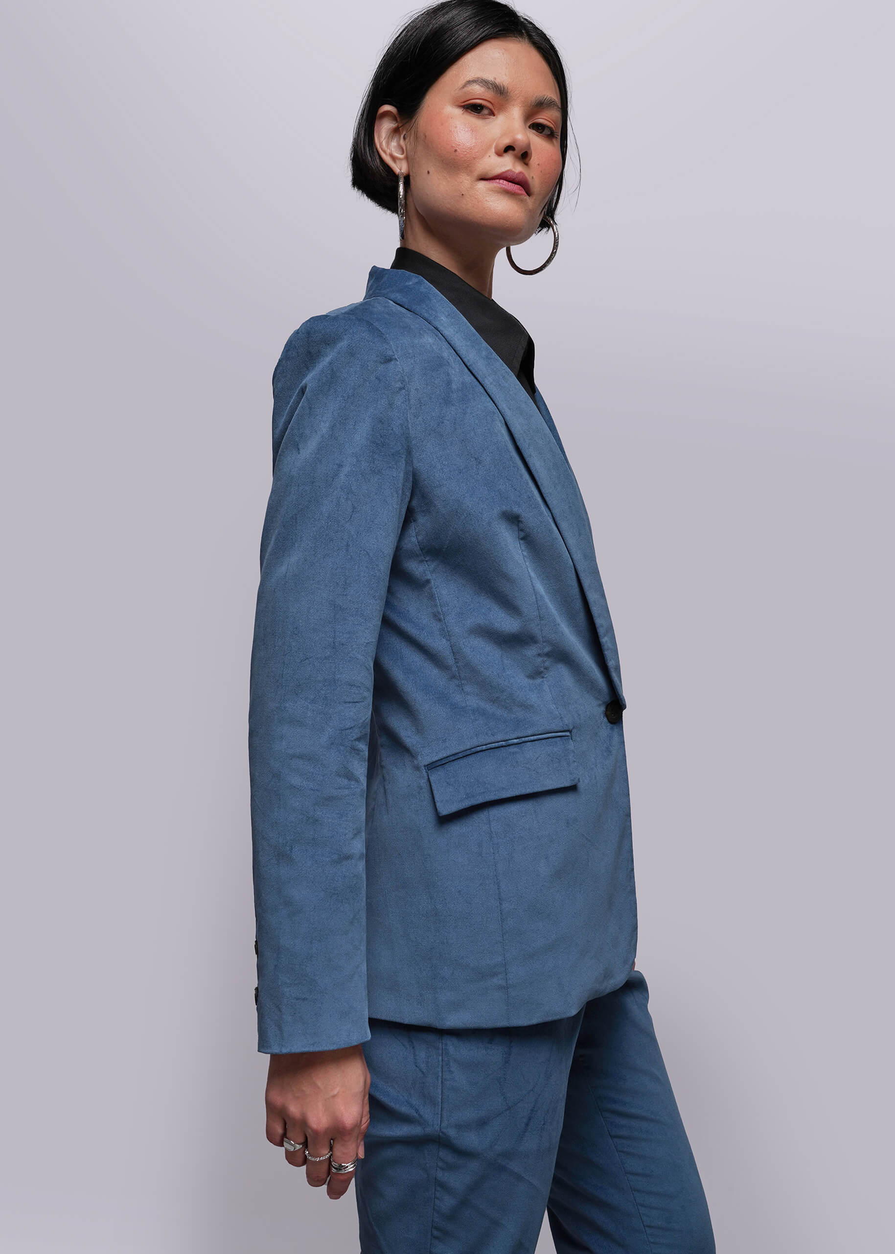 S=Person wearing a blue suit against a plain background