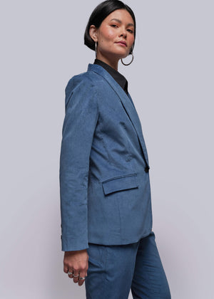 S=Person wearing a blue suit against a plain background