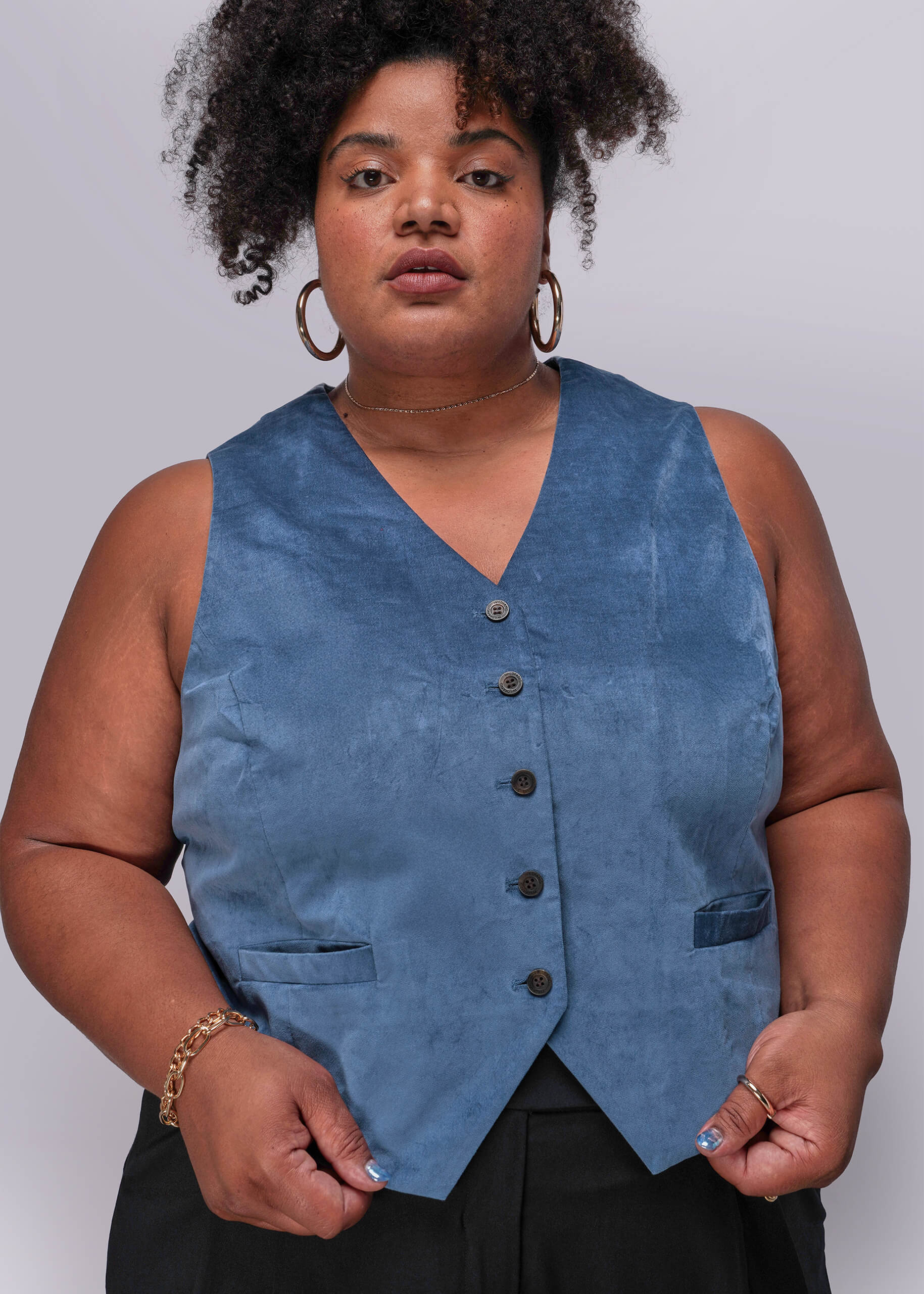 1X=Person wearing a blue vest against a plain background