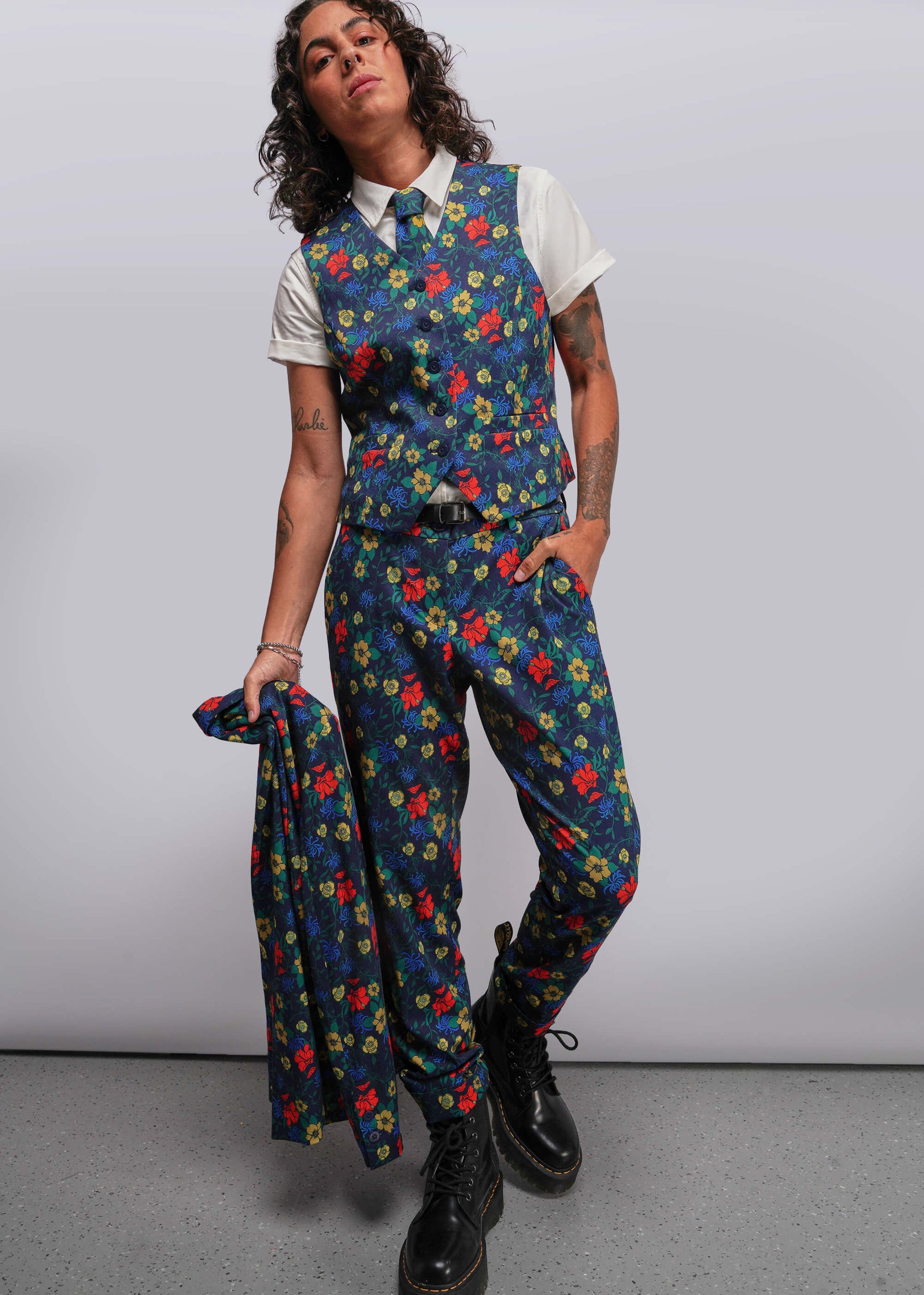 S=Person wearing a colorful floral suit with a white shirt against a plain background