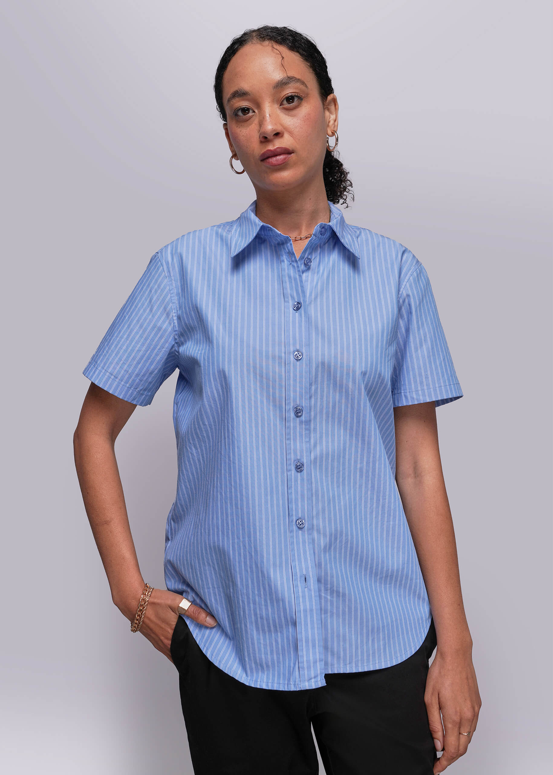 S=Person wearing a blue striped shirt against a gray background