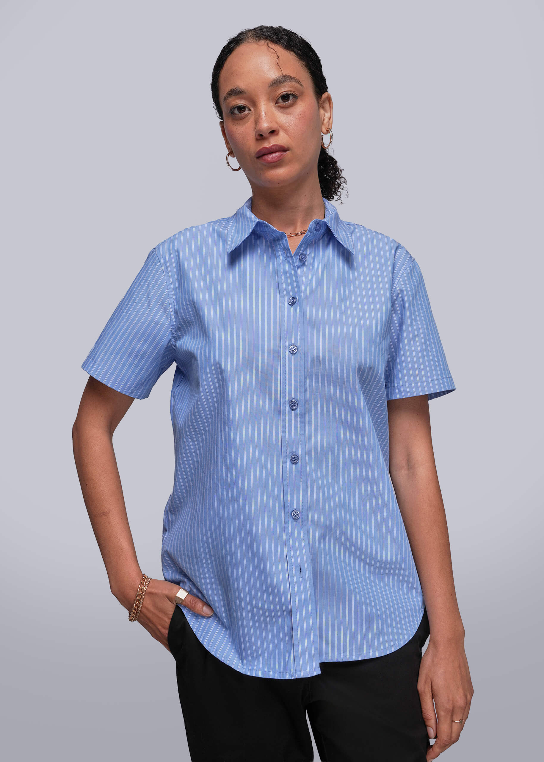 S=Person wearing a blue striped shirt against a gray background