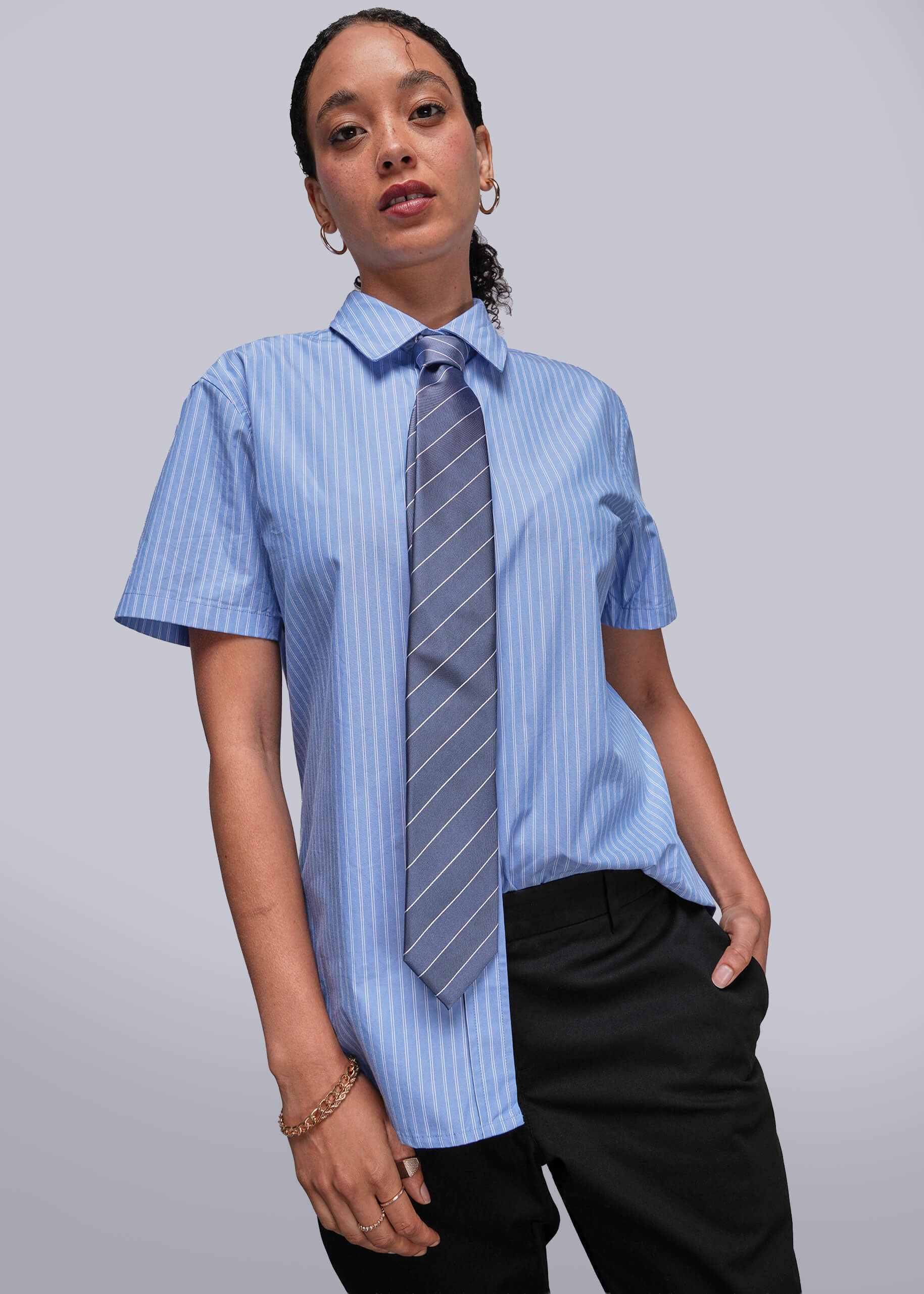 S=Person wearing a blue striped shirt with a tie against a plain background
