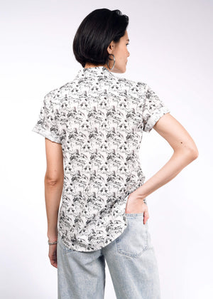 S=A person with short dark hair faces away, displaying The Essential Button Up—tailored with bold prints and Wildfang branded buttons—and light blue jeans against a plain white background.