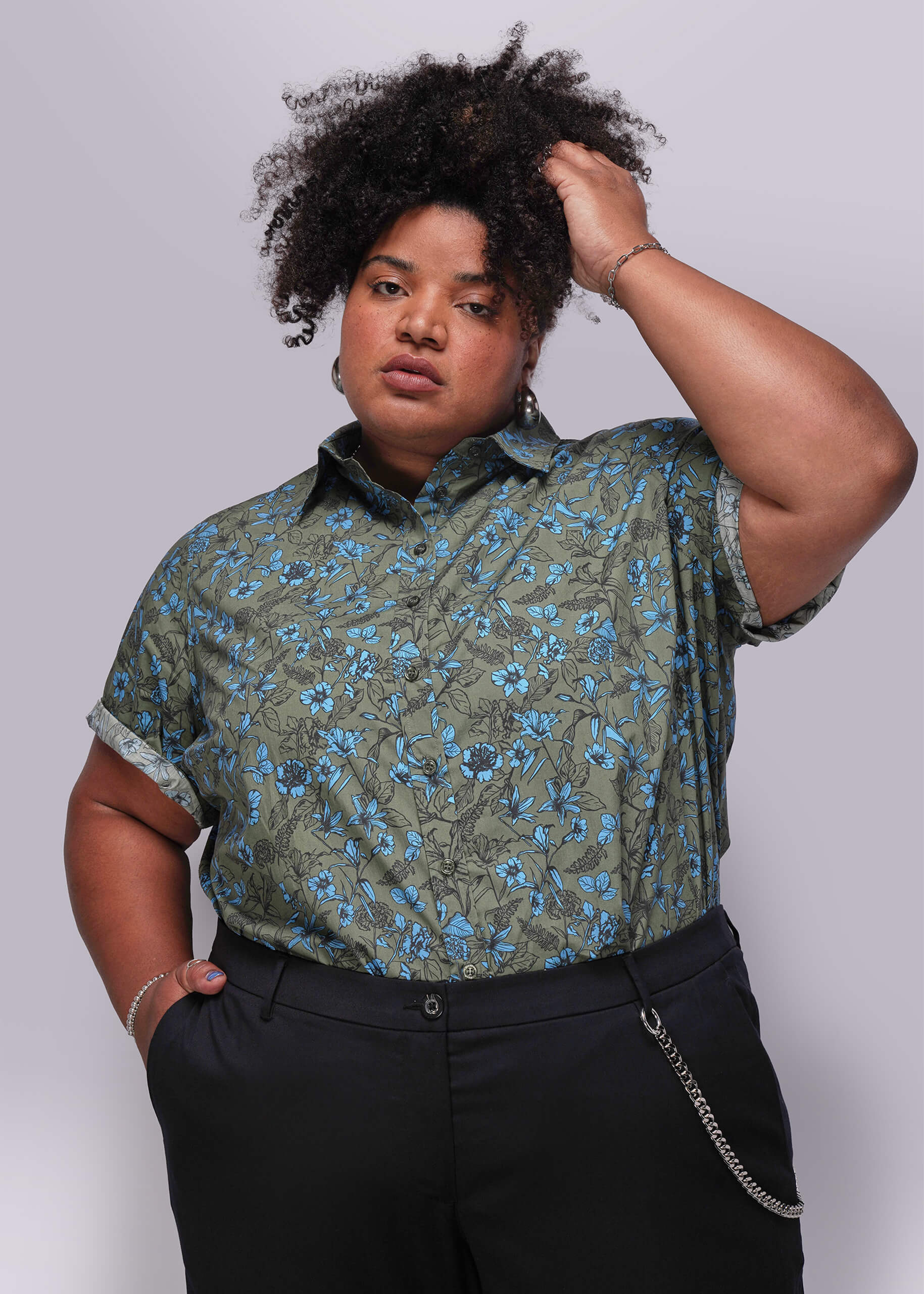 1X=Person wearing a green floral shirt against a plain background