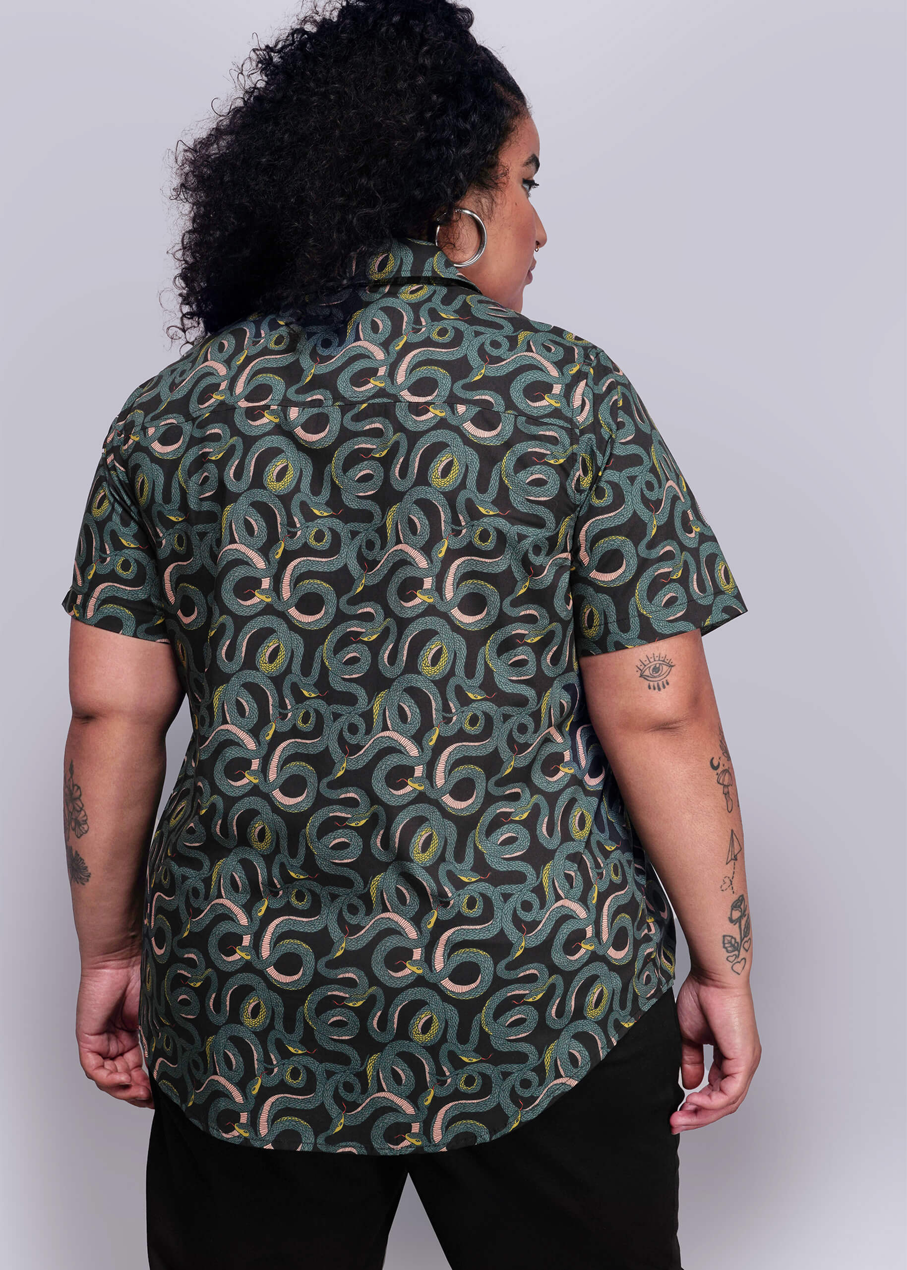 1X=Person wearing a green patterned shirt against a plain background