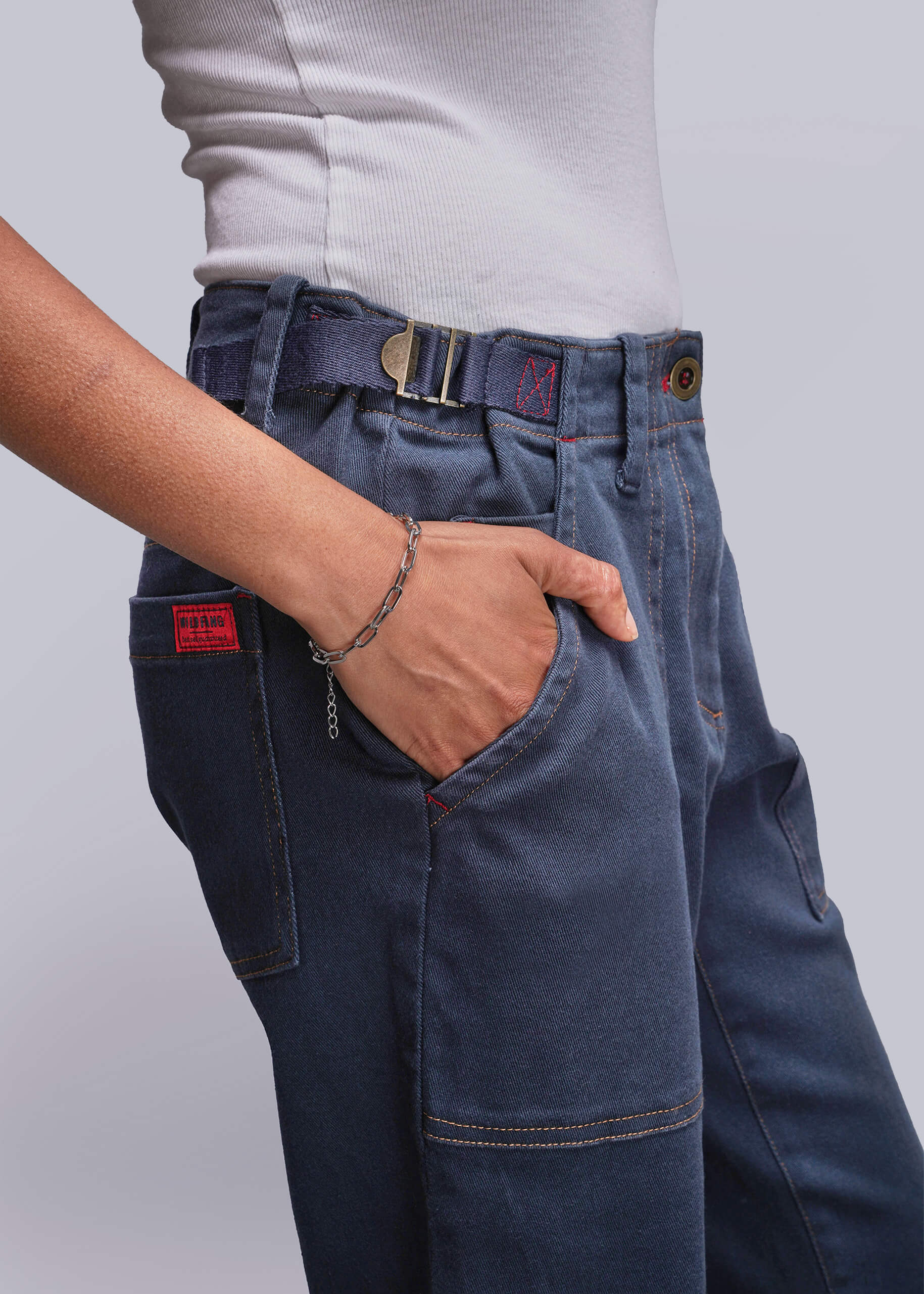 S=Person wearing blue jeans with a gray background