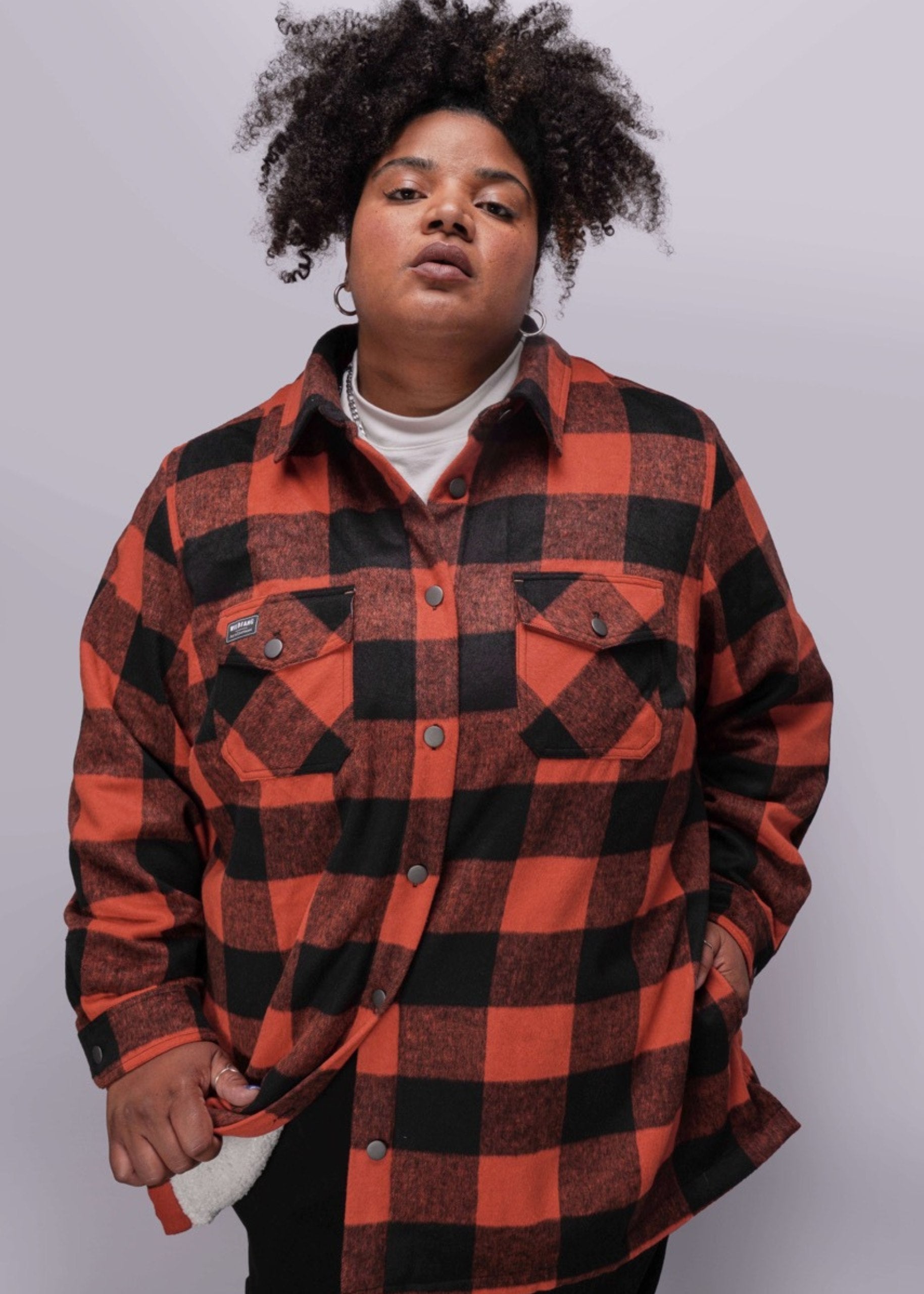 1X=Person wearing a red and black checkered shirt on a white background
