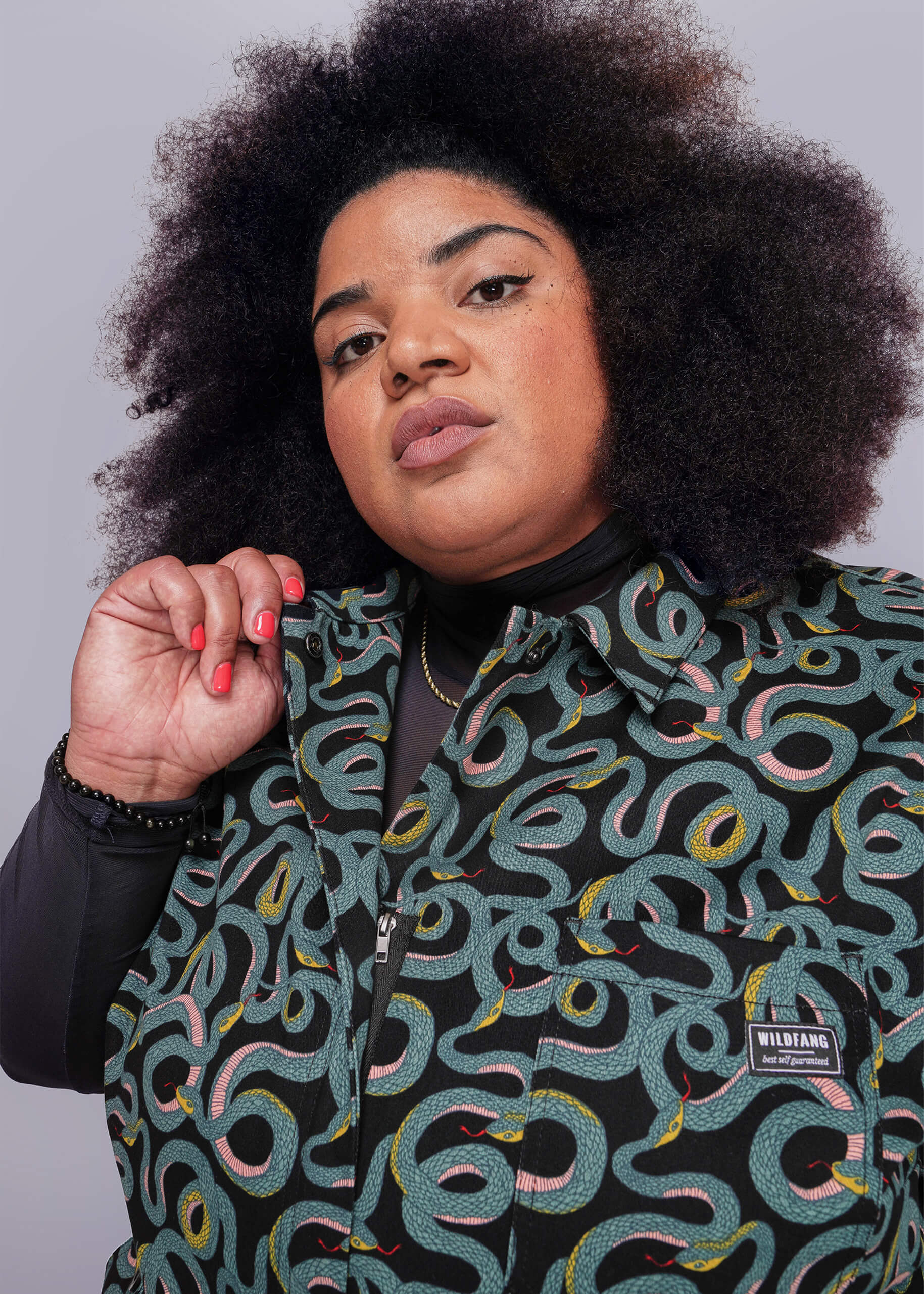 1X=Person wearing a patterned jumpsuit with a visible Wildfang logo against a plain background