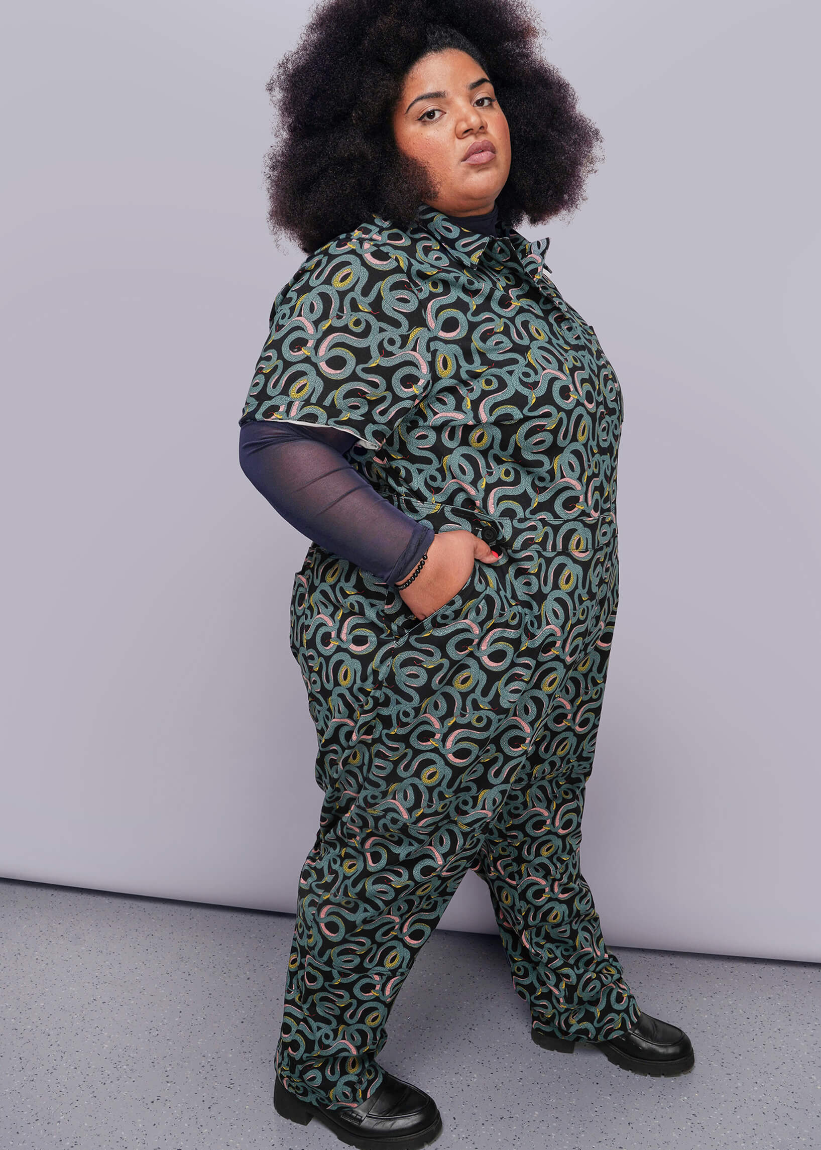 1X=Person wearing a patterned outfit against a plain background