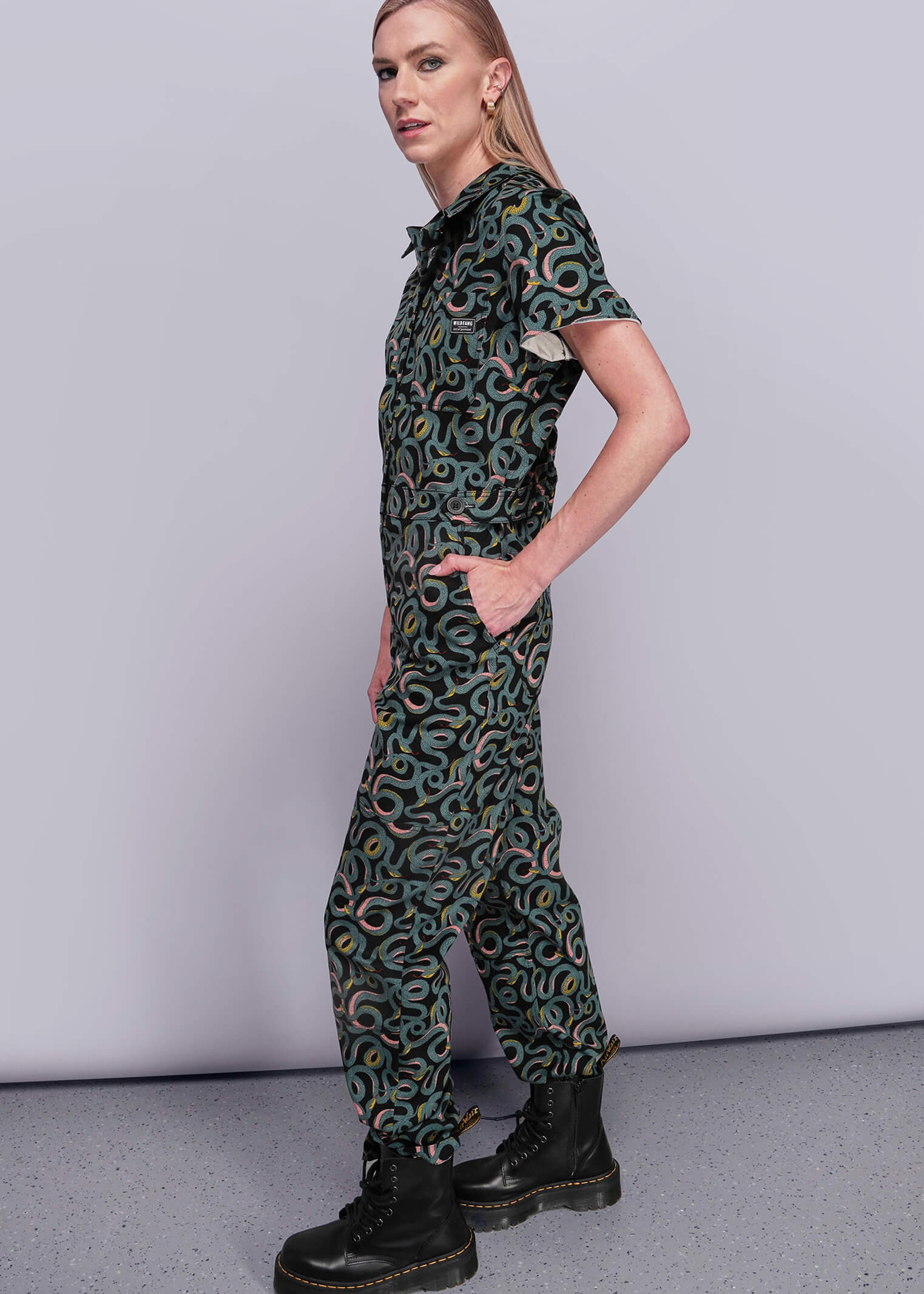 S=Person wearing a patterned jumpsuit on a plain background