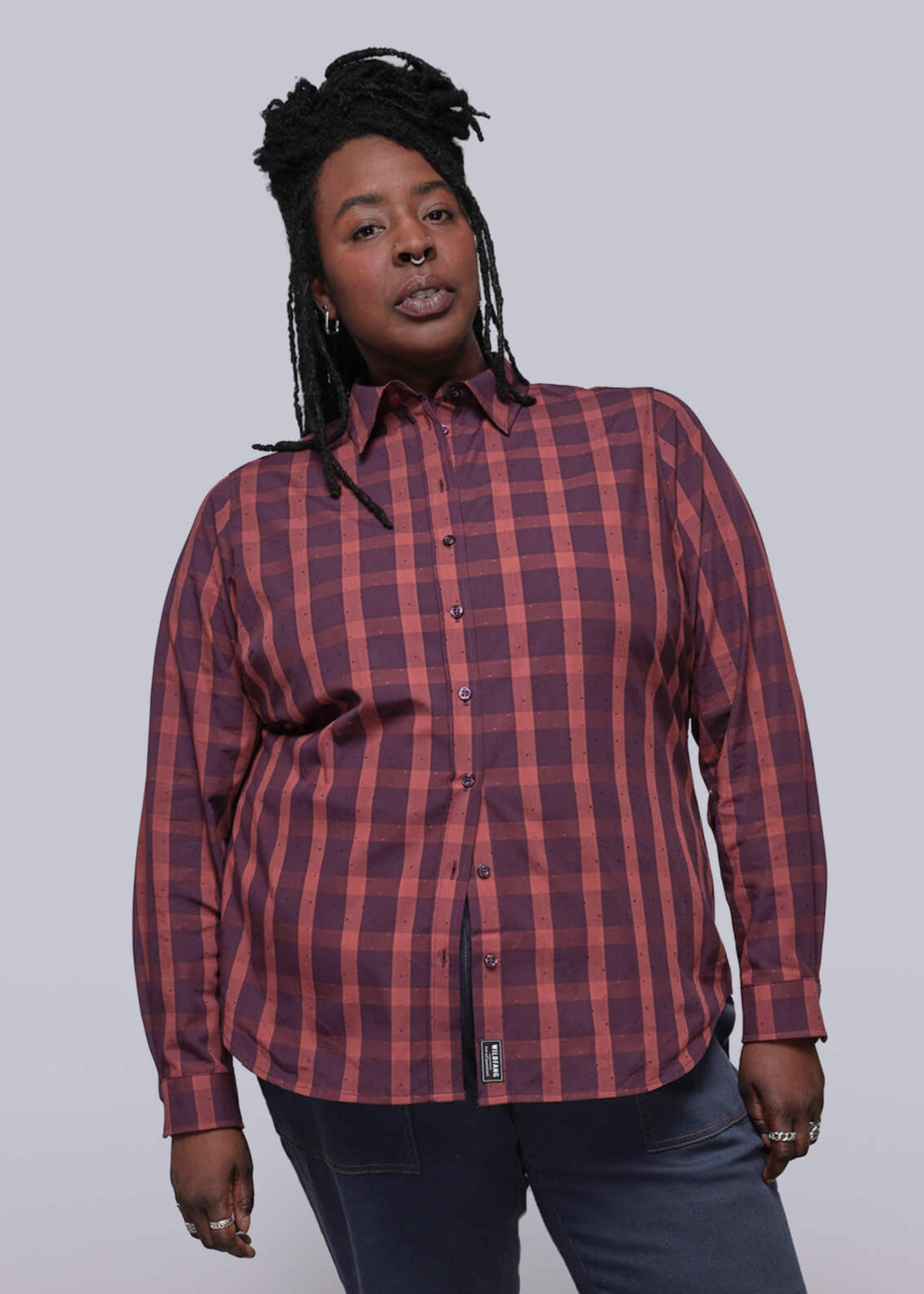 1X=Person wearing a red plaid shirt against a plain background