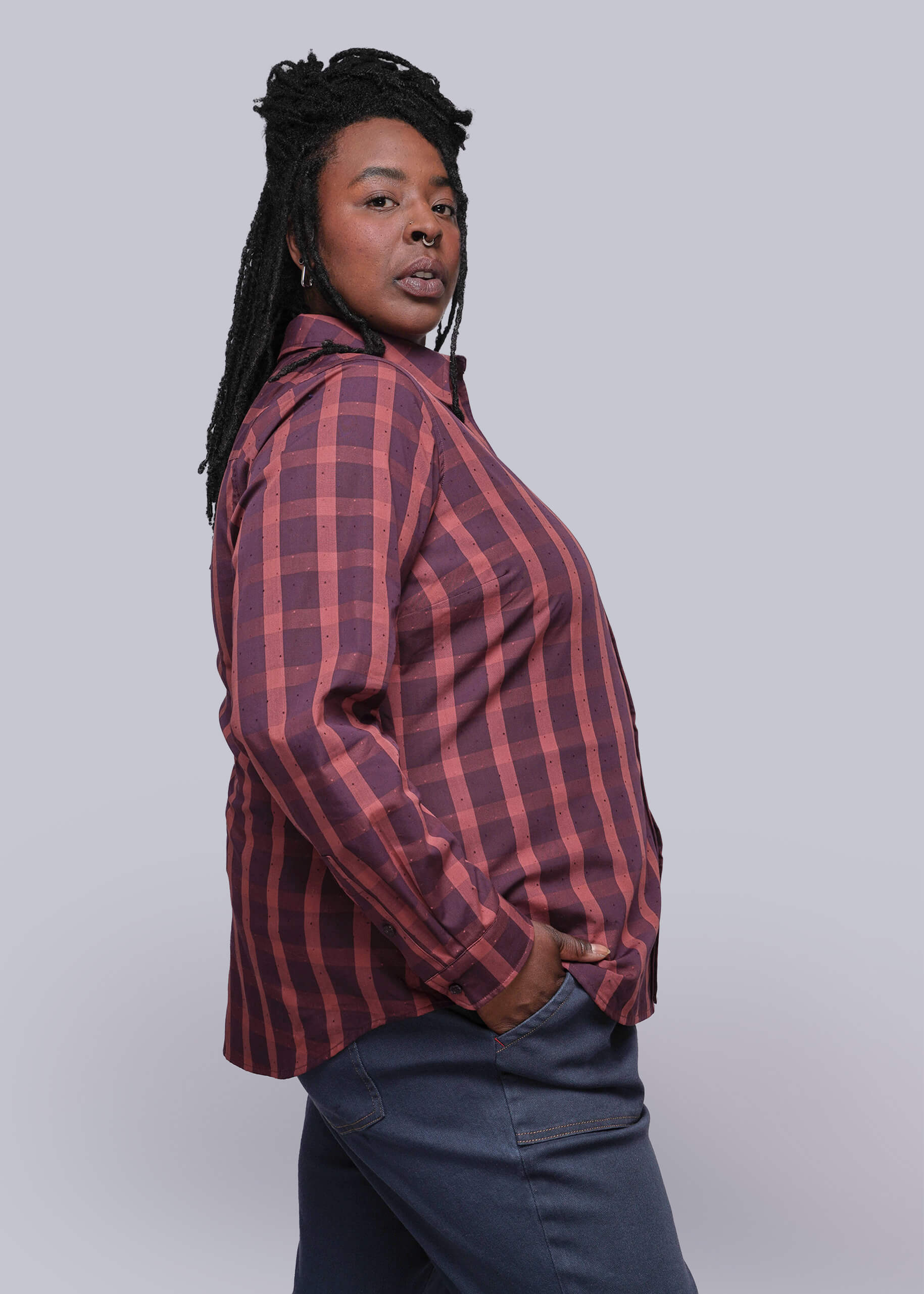 1X=Person wearing a red and burgundy plaid shirt against a plain background