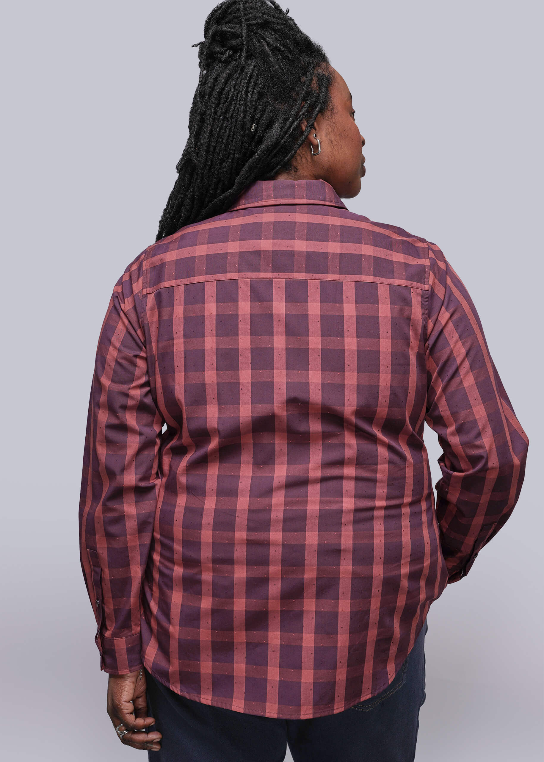 1X=Person wearing a red and burgundy plaid shirt against a plain background