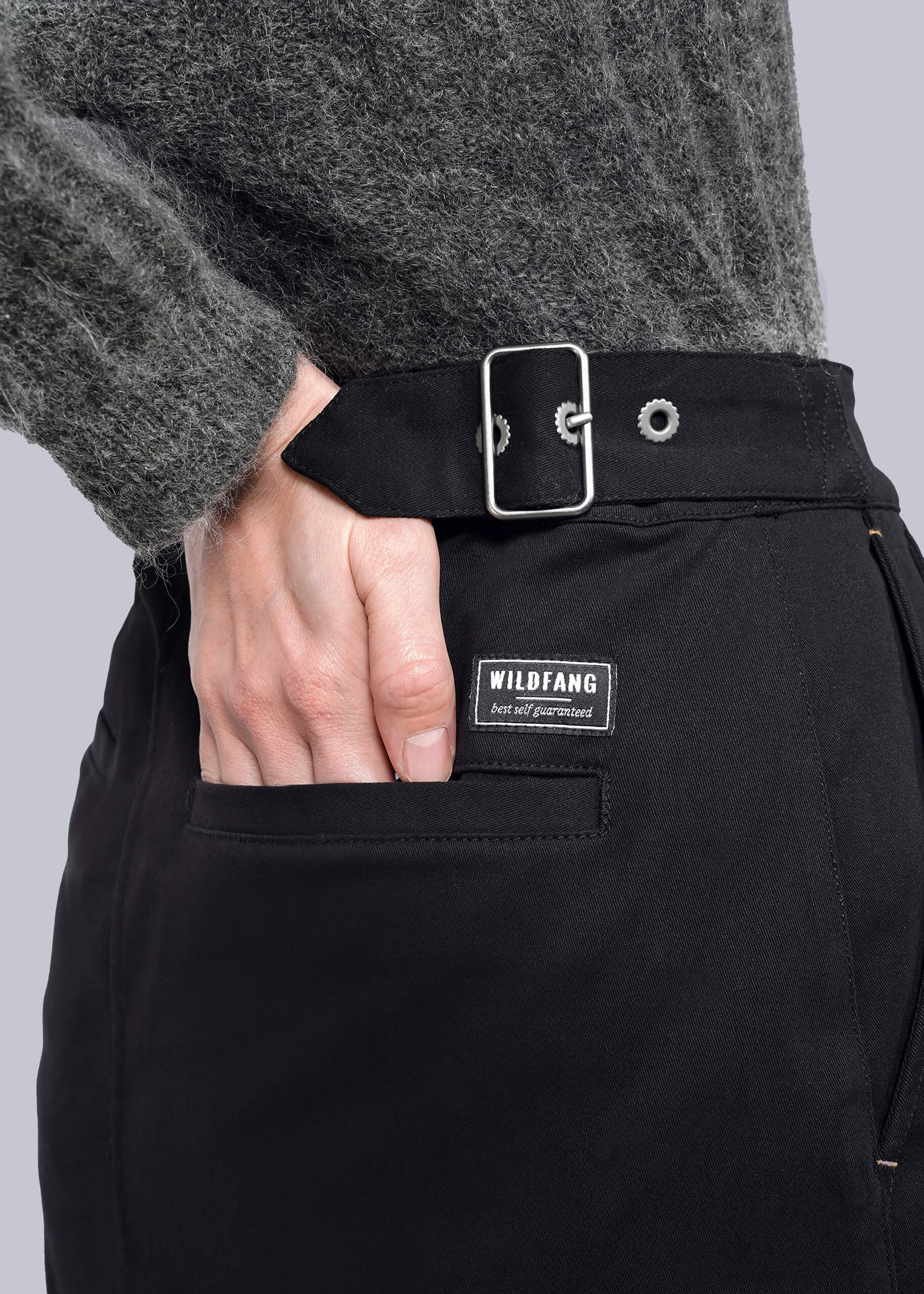 S= A person wears a fuzzy gray sweater and The Essential Utility Wrap Skirt, which features an adjustable waistband and a WILDFANG label above the front pocket, with their hand resting in the pocket.