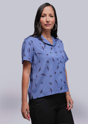 S=Woman wearing a blue patterned shirt against a plain background