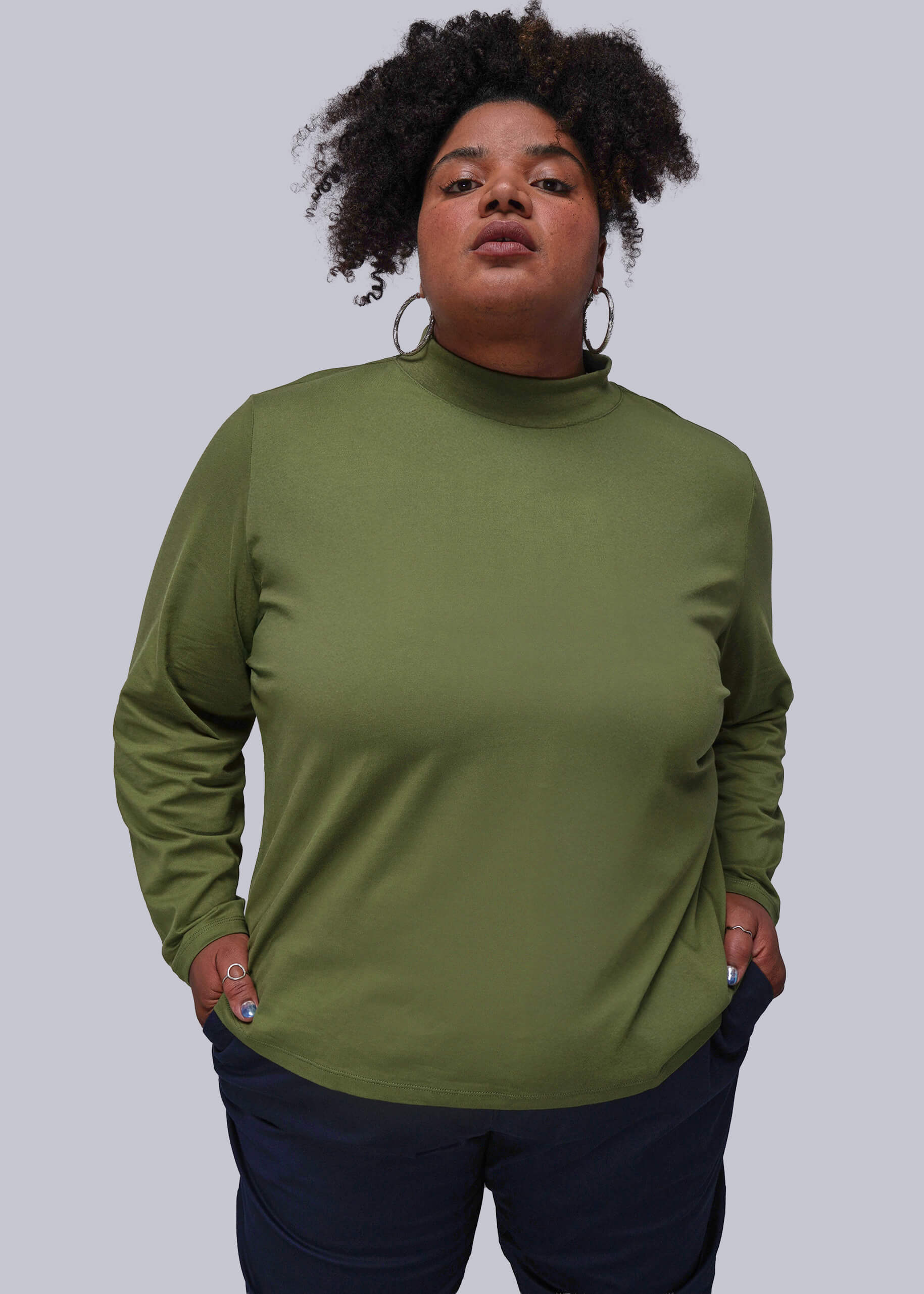 1X=Person wearing a green long-sleeve top against a plain background